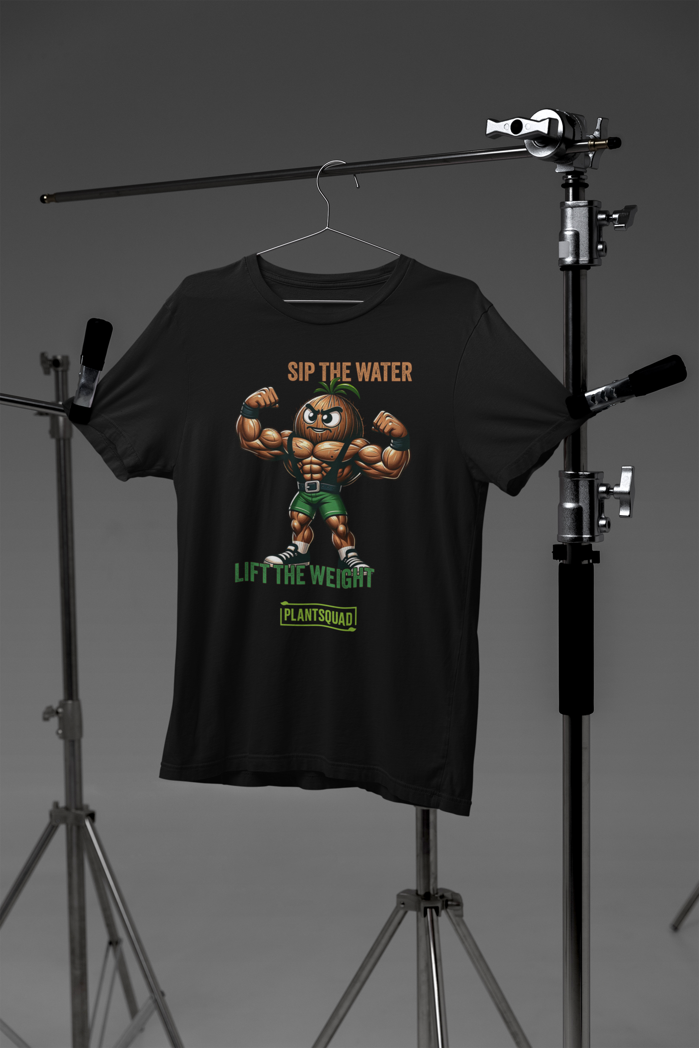 A Plantsquad Coconut "Sip The Water Lift The Weight" - Unisex T-Shirt features an illustration of a muscular, anthropomorphic walnut flexing its biceps. Above the walnut, text reads "SIP THE WATER," and below it, "LIFT THE WEIGHT." At the bottom, the green logo proudly displays "#plantsquad.