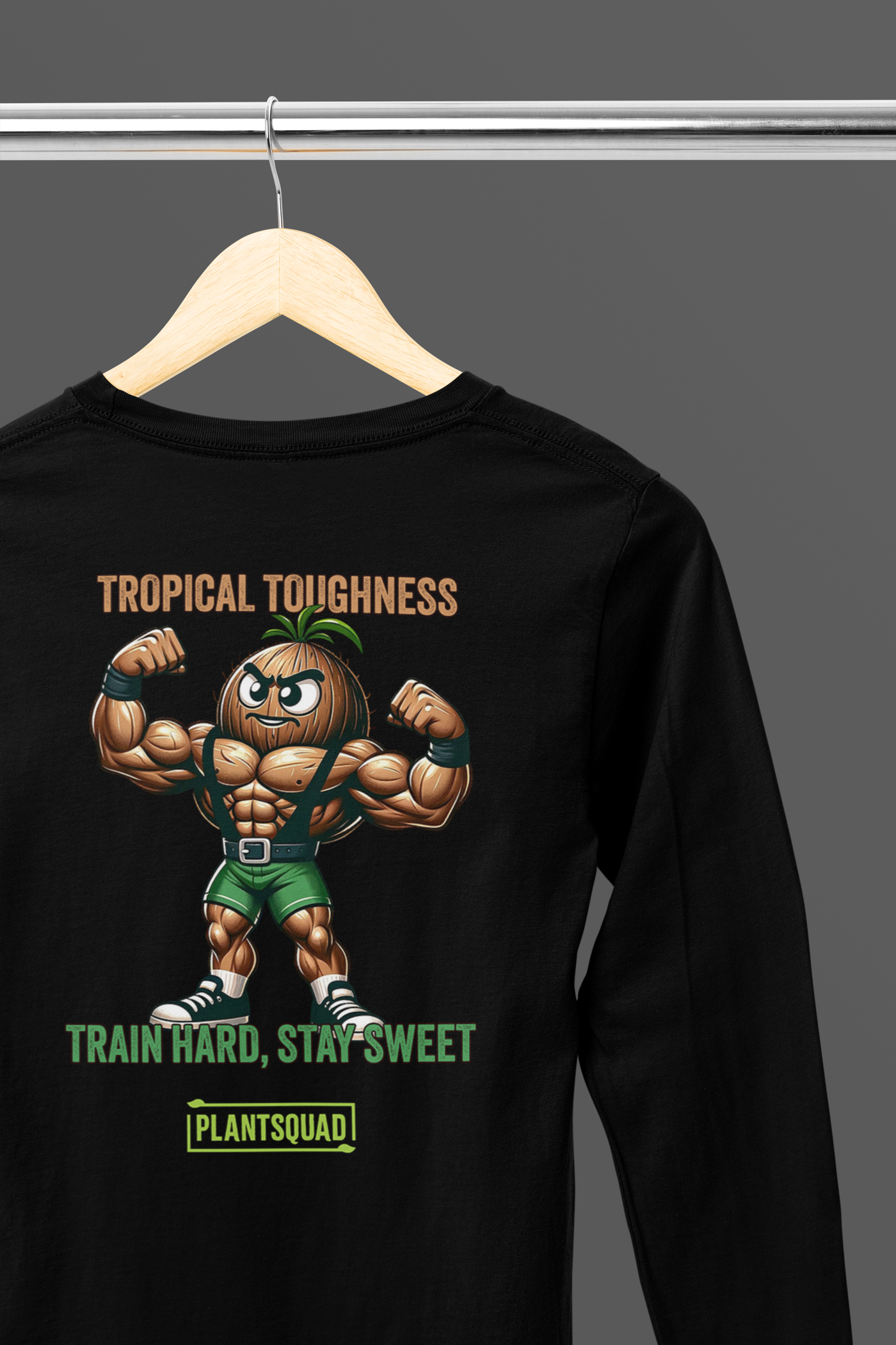 A Plantsquad Coconut "Tropical Toughness Train Hard Stay Sweet" - Unisex Long Sleeve T-Shirt features a muscular cartoon pineapple flexing its arms. Text above reads "Tropical Toughness" and below reads "Train Hard, Stay Sweet." The phrase "PlantSquad" appears at the bottom. Perfect for those embracing a plant-based lifestyle, the design is colorful and vibrant.