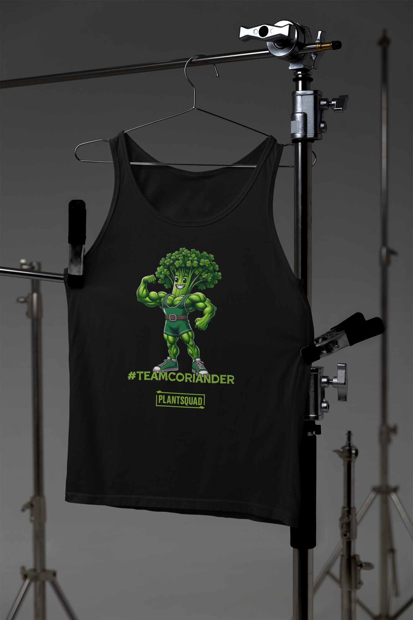 The Plantsquad Coriander "Team Coriander" - Unisex Tank Top showcases a muscular cartoon broccoli flexing its bicep, perfect for gym enthusiasts. Below the character, the text "#TeamCoriander" stands out, while "PlantSquad" is displayed inside a rectangle. Ideal for those embracing a vegan lifestyle.