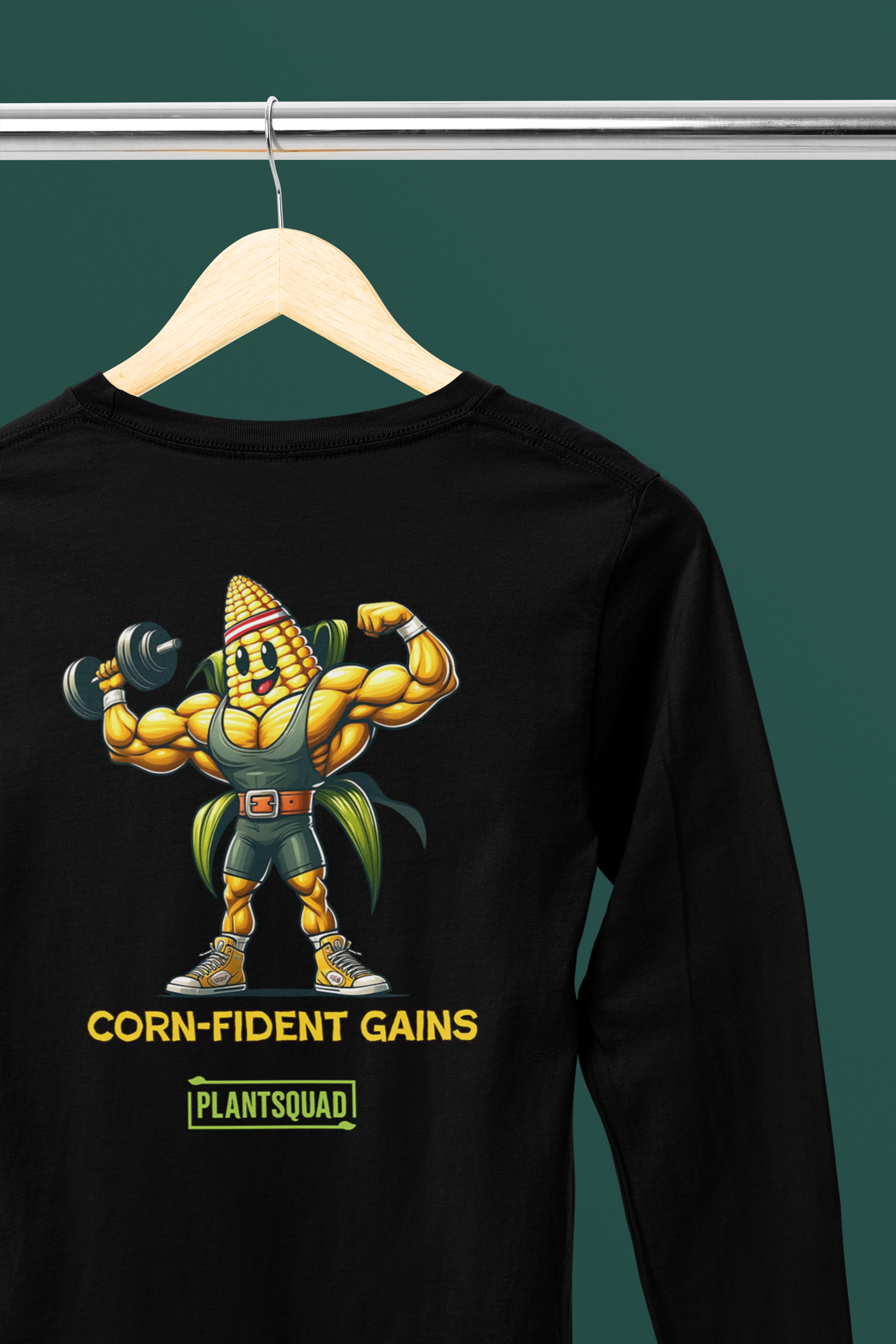 A Plantsquad Corn "Corn-fident Gains" - Unisex Long Sleeve T-Shirt features a muscular corn cob character lifting a dumbbell. The text below the character reads, "CORN-FIDENT GAINS" and "PLANTSQUAD," perfect for those embracing a plant-based, vegan lifestyle through fitness apparel.