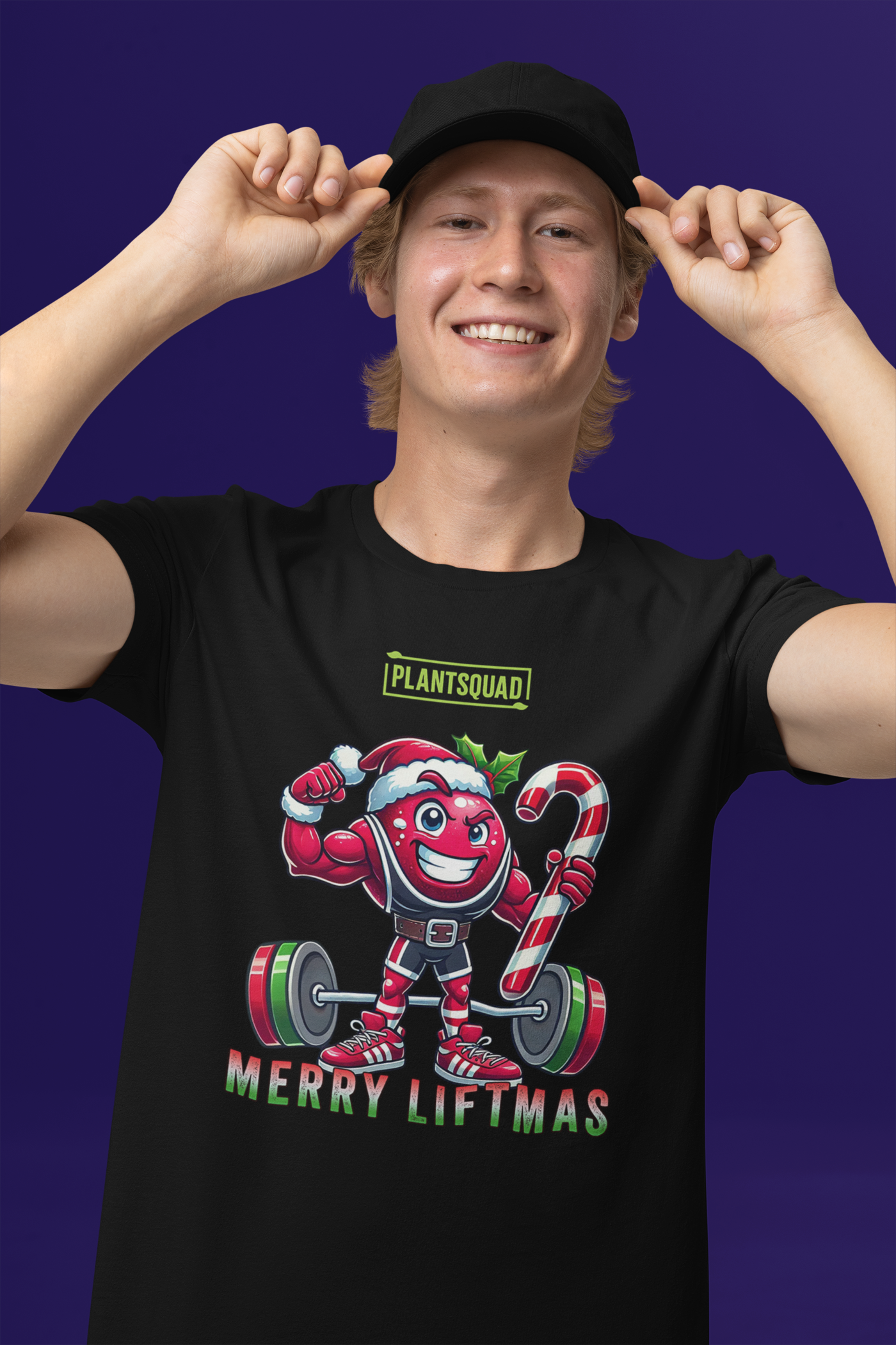 A model featuring a muscled cranberry cartoon character flexing its arms holding a candy cane.  A small green logo "PLANTSQUAD" appears above the character, "MERRY LIFTMAS" below. Perfect for those embracing a plant-based or vegan lifestyle that are into fitness