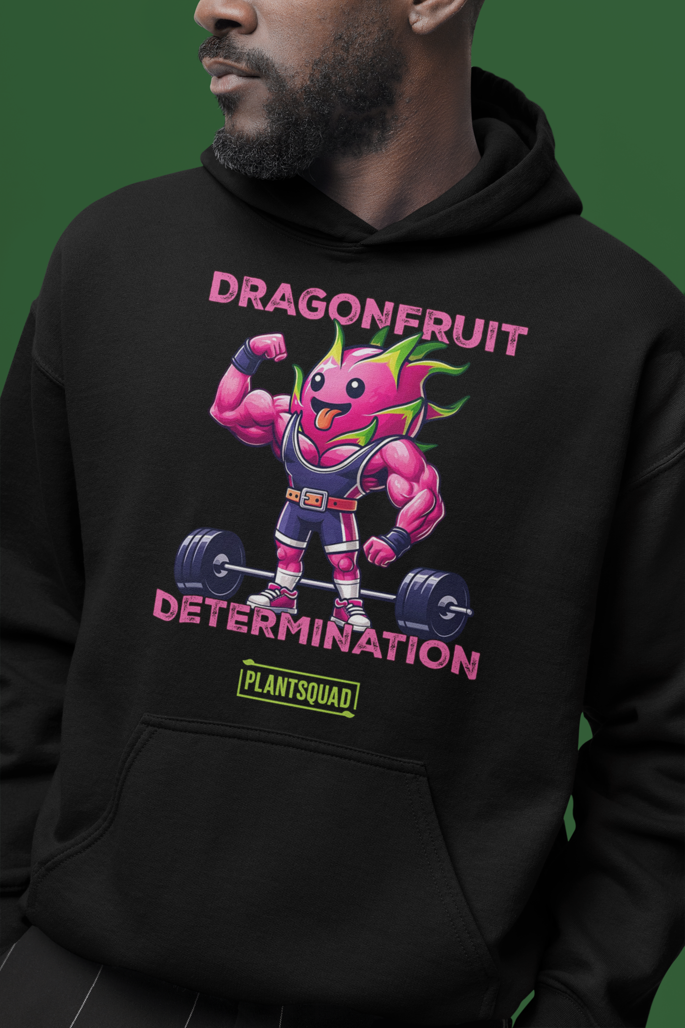 This Plantsquad Dragonfruit "Dragonfruit Determination" - Unisex Hoodie features a muscular dragonfruit character lifting barbells, with text above and below reading "Dragonfruit Determination." The bright pink dragonfruit with green spikes showcases strength and determination, promoting a vegan lifestyle. The "Plantsquad" logo is displayed at the bottom.