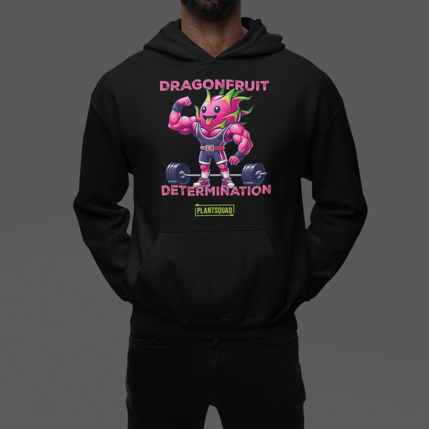 This Plantsquad Dragonfruit "Dragonfruit Determination" - Unisex Hoodie features a muscular dragonfruit character lifting barbells, with text above and below reading "Dragonfruit Determination." The bright pink dragonfruit with green spikes showcases strength and determination, promoting a vegan lifestyle. The "Plantsquad" logo is displayed at the bottom.