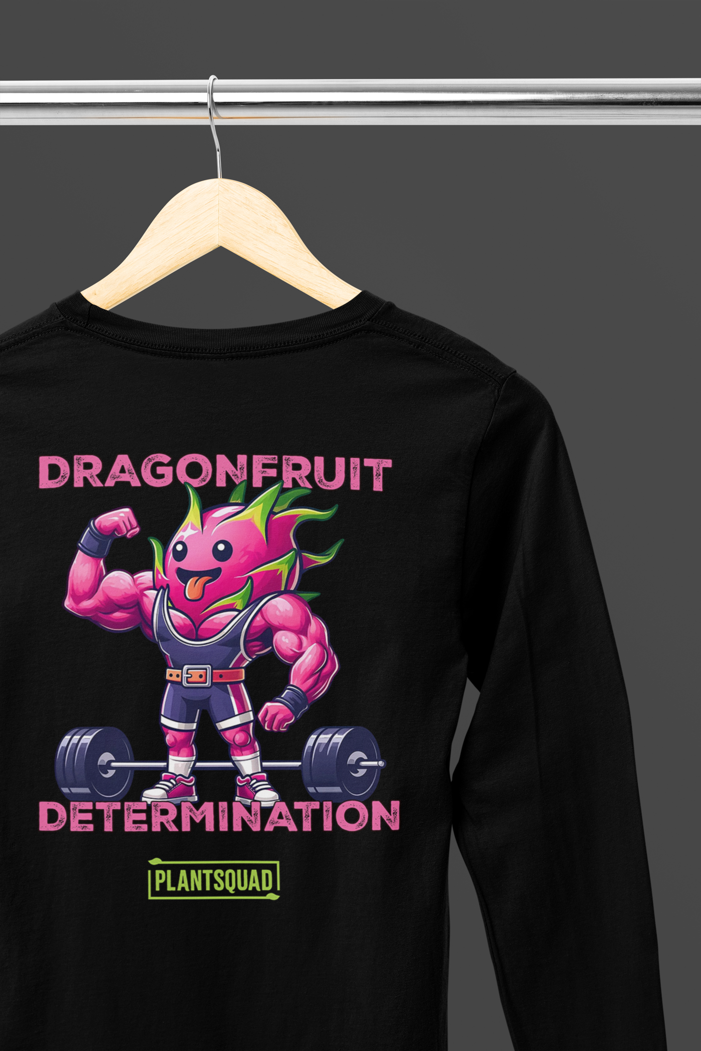 A Plantsquad Dragonfruit "Dragonfruit Determination" - Unisex Long Sleeve T-Shirt featuring a muscular anthropomorphic dragon fruit lifting a barbell. The text above reads "DRAGONFRUIT" and "DETERMINATION," while the text below says "PLANTSQUAD." The vibrant design highlights vegan fitness apparel with pink skin, green leaves, and purple gym attire.