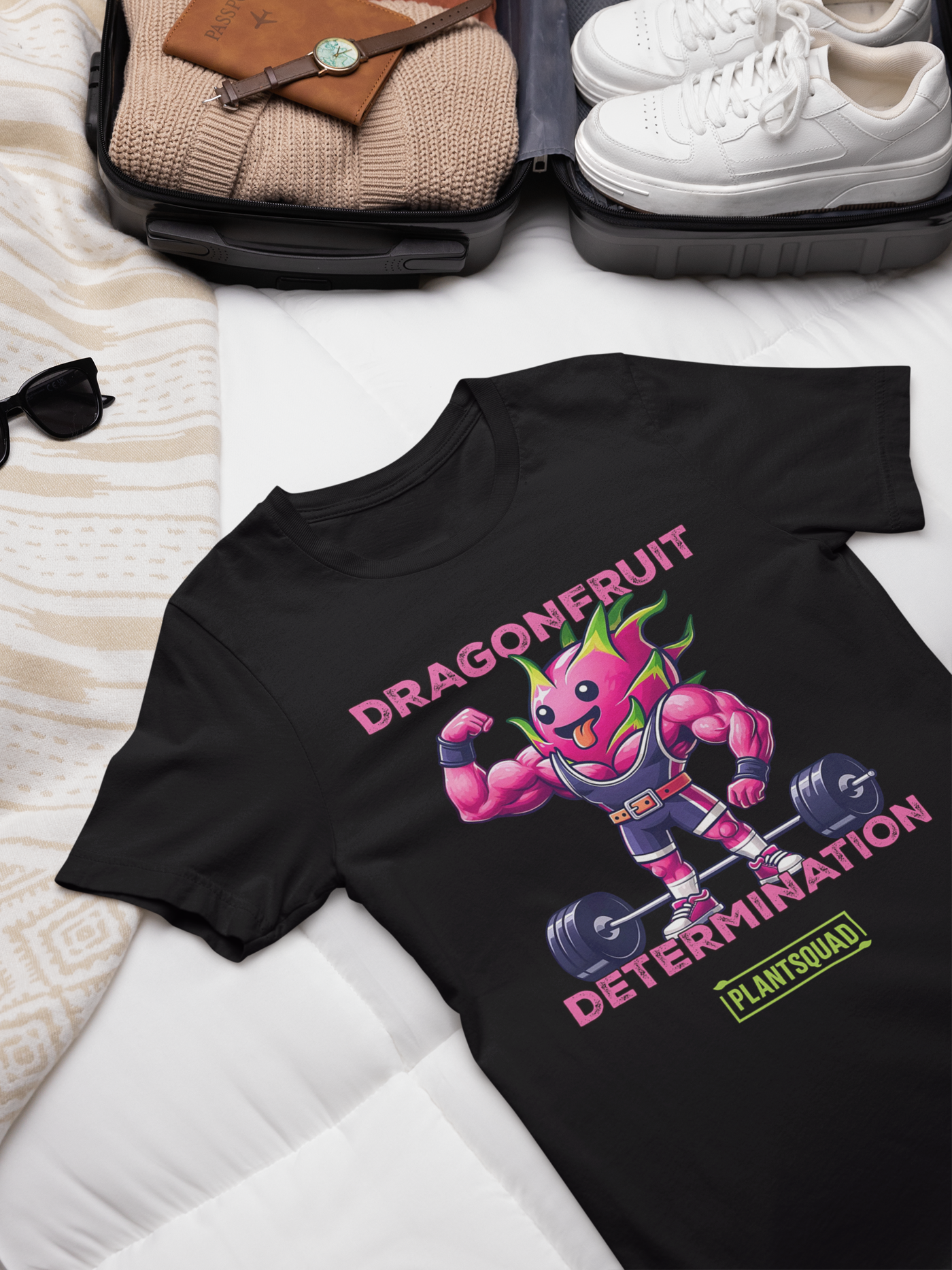 The Plantsquad Dragonfruit "Dragonfruit Determination" - Unisex T-Shirt features a black T-shirt with a muscular anthropomorphic dragon fruit character lifting weights. The text above the character reads "Dragonfruit" and below it reads "Determination." At the bottom, there's a stylish PlantSquad logo.