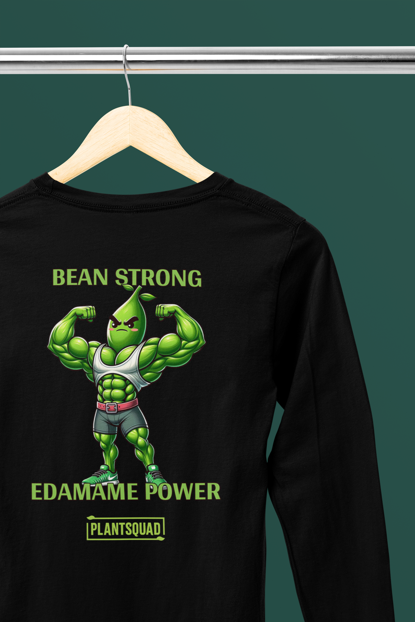 A Plantsquad Edamame "Bean Strong Edamame Power" - Unisex Long Sleeve T-Shirt featuring a muscular, anthropomorphic edamame bean flexing its biceps. The text above the character reads "BEAN STRONG," and below it reads "EDAMAME POWER." Perfect for those embracing a vegan fitness or plant-based lifestyle.