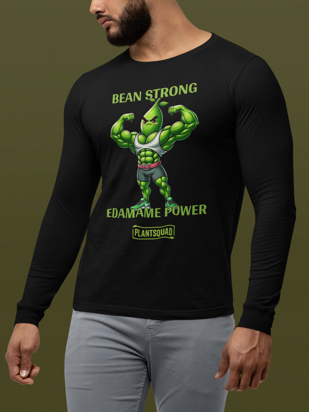 A Plantsquad Edamame "Bean Strong Edamame Power" - Unisex Long Sleeve T-Shirt featuring a muscular, anthropomorphic edamame bean flexing its biceps. The text above the character reads "BEAN STRONG," and below it reads "EDAMAME POWER." Perfect for those embracing a vegan fitness or plant-based lifestyle.