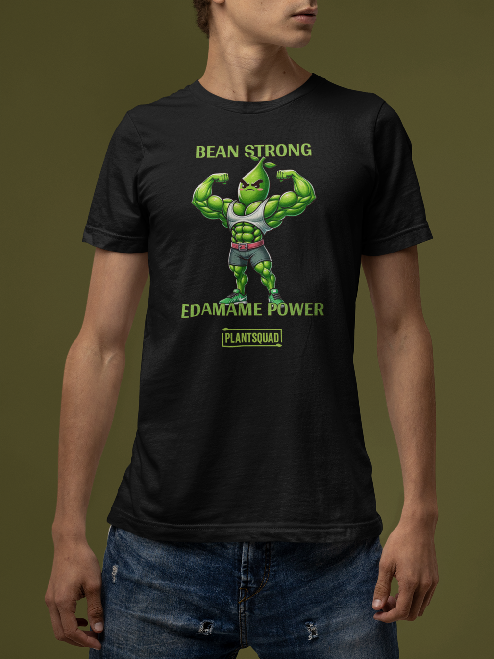 A Plantsquad Edamame "Bean Strong Edamame Power" - Unisex T-Shirt showcasing a cartoon edamame bean flexing its muscles. Above, the text reads "BEAN STRONG," with "EDAMAME POWER" below. At the bottom, "PLANTSQUAD" is featured within a green rectangular box, celebrating your love for plant-based strength.