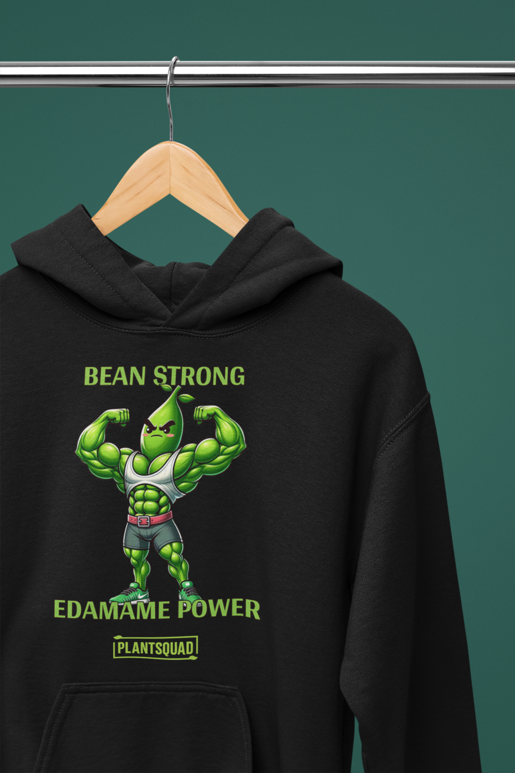 A black vegan gym hoodie featuring a muscular green bean character flexing its arms. The text above reads "BEAN STRONG" and below reads "EDAMAME POWER." Embrace the plant-based lifestyle with our Plantsquad Edamame "Bean Strong Edamame Power" - Unisex Hoodie, branded with "PLANTSQUAD" at the bottom.