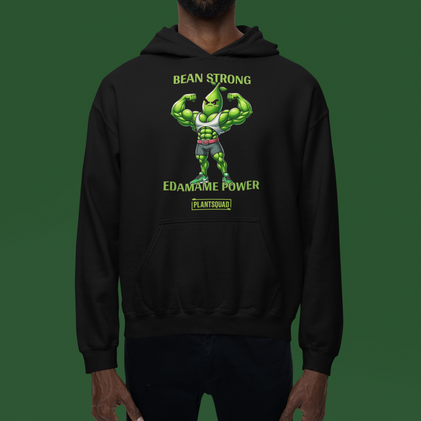 A black vegan gym hoodie featuring a muscular green bean character flexing its arms. The text above reads "BEAN STRONG" and below reads "EDAMAME POWER." Embrace the plant-based lifestyle with our Plantsquad Edamame "Bean Strong Edamame Power" - Unisex Hoodie, branded with "PLANTSQUAD" at the bottom.