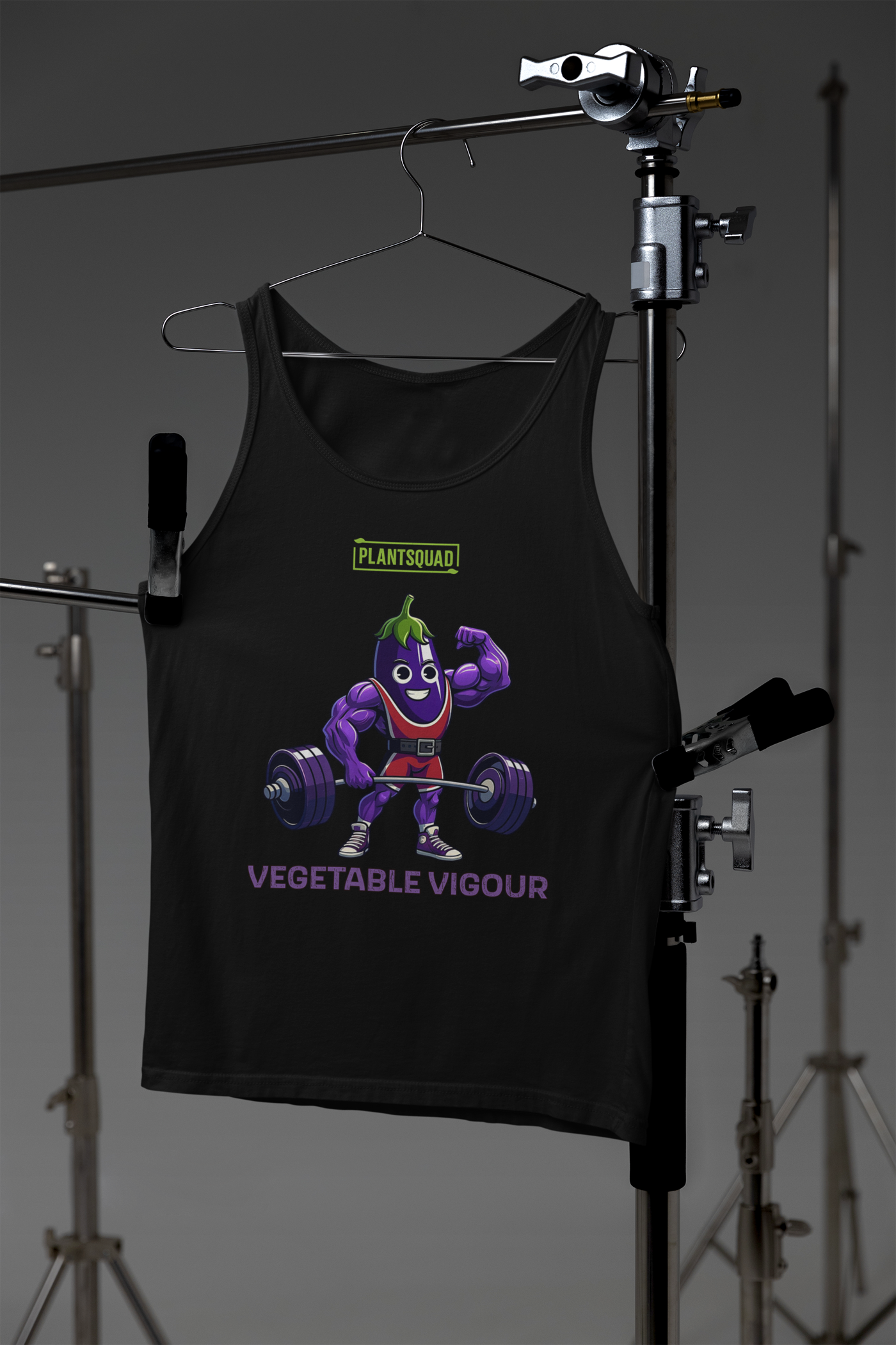 Black vegan tank top featuring a muscular, purple cartoon eggplant character lifting heavy barbells. The eggplant is smiling and flexing one arm. Perfect for gym enthusiasts with a plant-based lifestyle, this top has "PLANT SQUAD" above the character and "VEGETABLE VIGOUR" below in bold text. Introducing the Plantsquad Eggplant "Vegetable Vigour" - Unisex Tank Top.