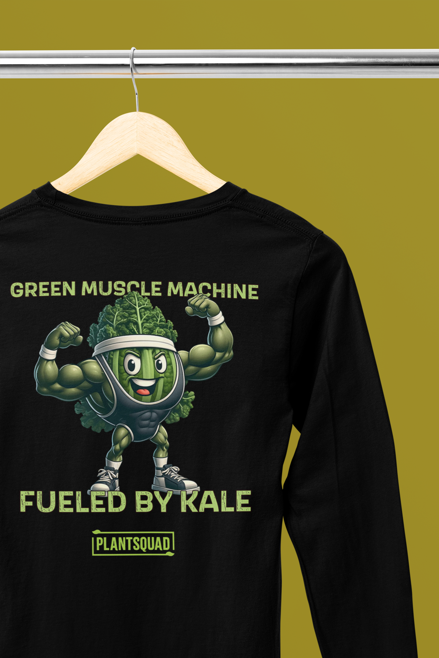 Plantsquad Kale "Green Muscle Machine Fueled By Kale" - Unisex Long Sleeve T-Shirt featuring a muscular cartoon kale character flexing its arms. Above the character, text reads, "GREEN MUSCLE MACHINE," and below it, "FUELED BY KALE." Perfect for fitness enthusiasts embracing a vegan lifestyle! The bottom of the design includes "PLANTSQUAD" inside a rectangular box.