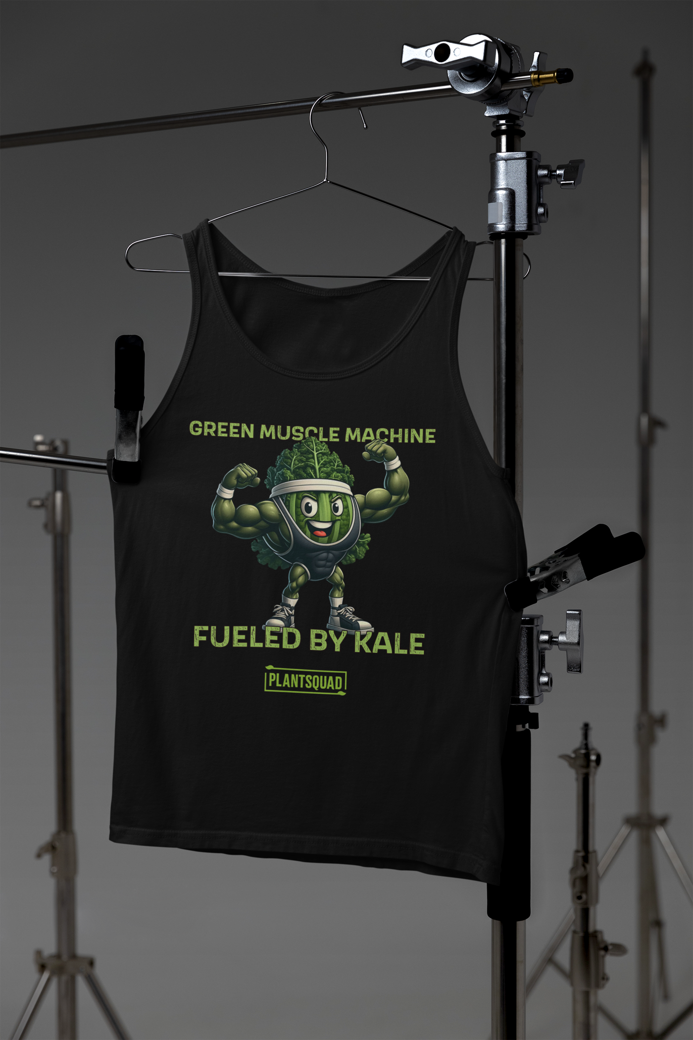 The Plantsquad Kale "Green Muscle Machine Fueled By Kale" - Unisex Tank Top features a muscly kale cartoon flexing its biceps. Above the graphic, the text reads "GREEN MUSCLE MACHINE," and below it, "FUELED BY KALE." At the bottom, the word "PLANTSQUAD" appears in a green banner. Perfect for vegan gym enthusiasts embracing a plant-based lifestyle.