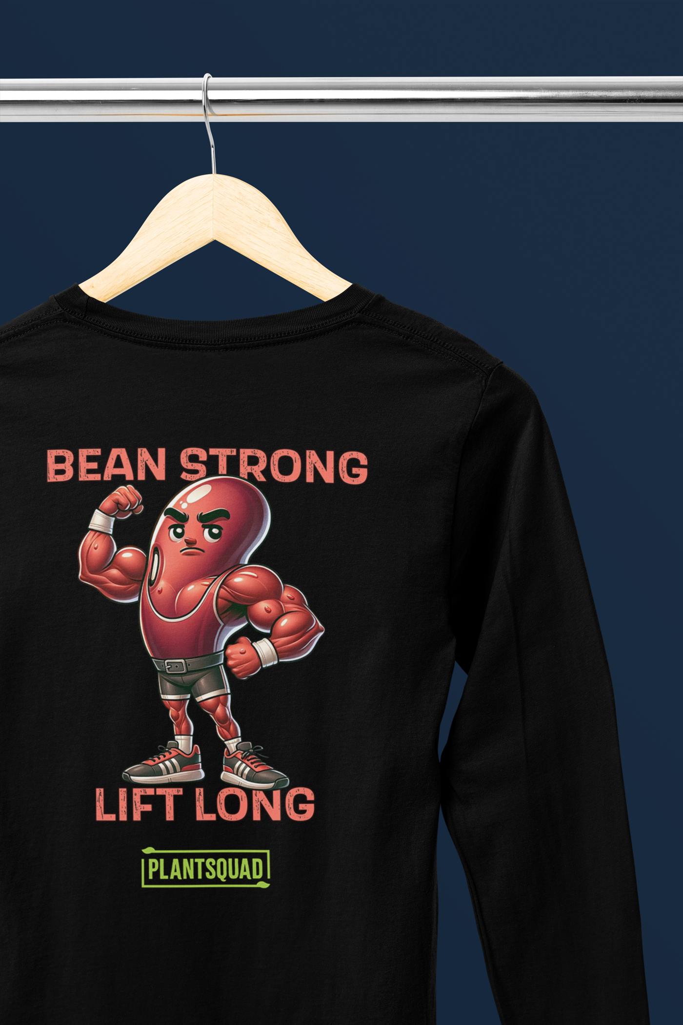 A Plantsquad Kidney Bean "Beans Are Protein" - Unisex Long Sleeve T-Shirt with a graphic showing a muscular animated bean flexing its arm. The text above the bean reads "BEANS" and below it reads "ARE PROTEIN." At the bottom, there is a green and yellow banner with the word "PLANTSQUAD." Perfect for fitness enthusiasts embracing a vegan lifestyle.