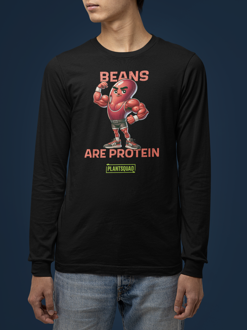 A Plantsquad Kidney Bean "Bean Strong Lift Long" - Unisex Long Sleeve T-Shirt featuring a muscular cartoon kidney bean character flexing its biceps. Above the character, the text reads "BEAN STRONG," and below, "LIFT LONG." Crafted from comfortable fabric, it's perfect for fitness enthusiasts embracing a vegan lifestyle. At the bottom, a green rectangle displays "PLANTSQUAD" in all caps.