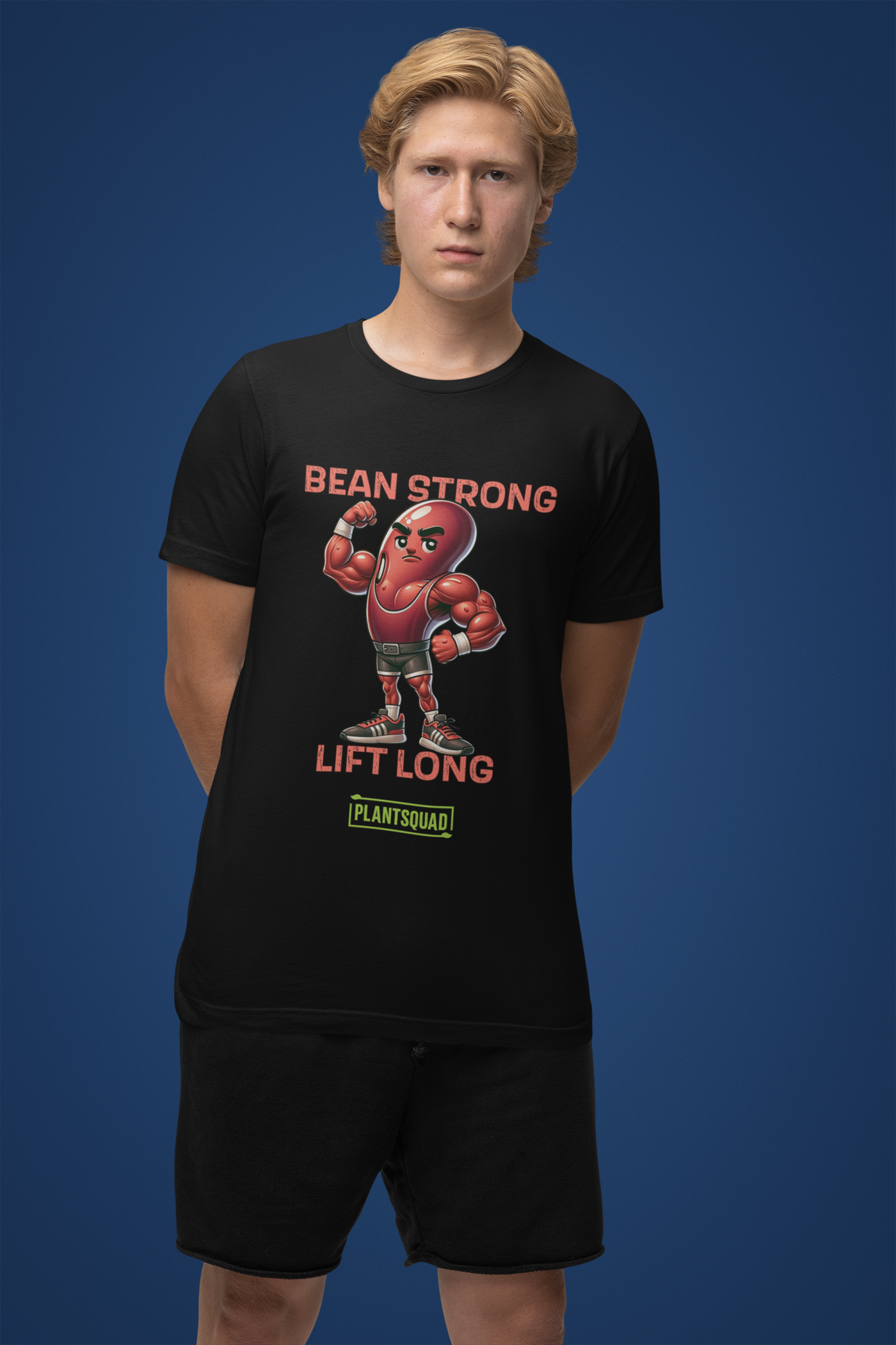 A black t-shirt featuring a muscular cartoon bean character flexing its arm. Above the character are the words "BEAN STRONG" and below it, "LIFT LONG." The bottom of this Plantsquad Kidney Bean "Bean Strong Lift Long" - Unisex T-Shirt proudly displays the "PLANTSQUAD" logo.