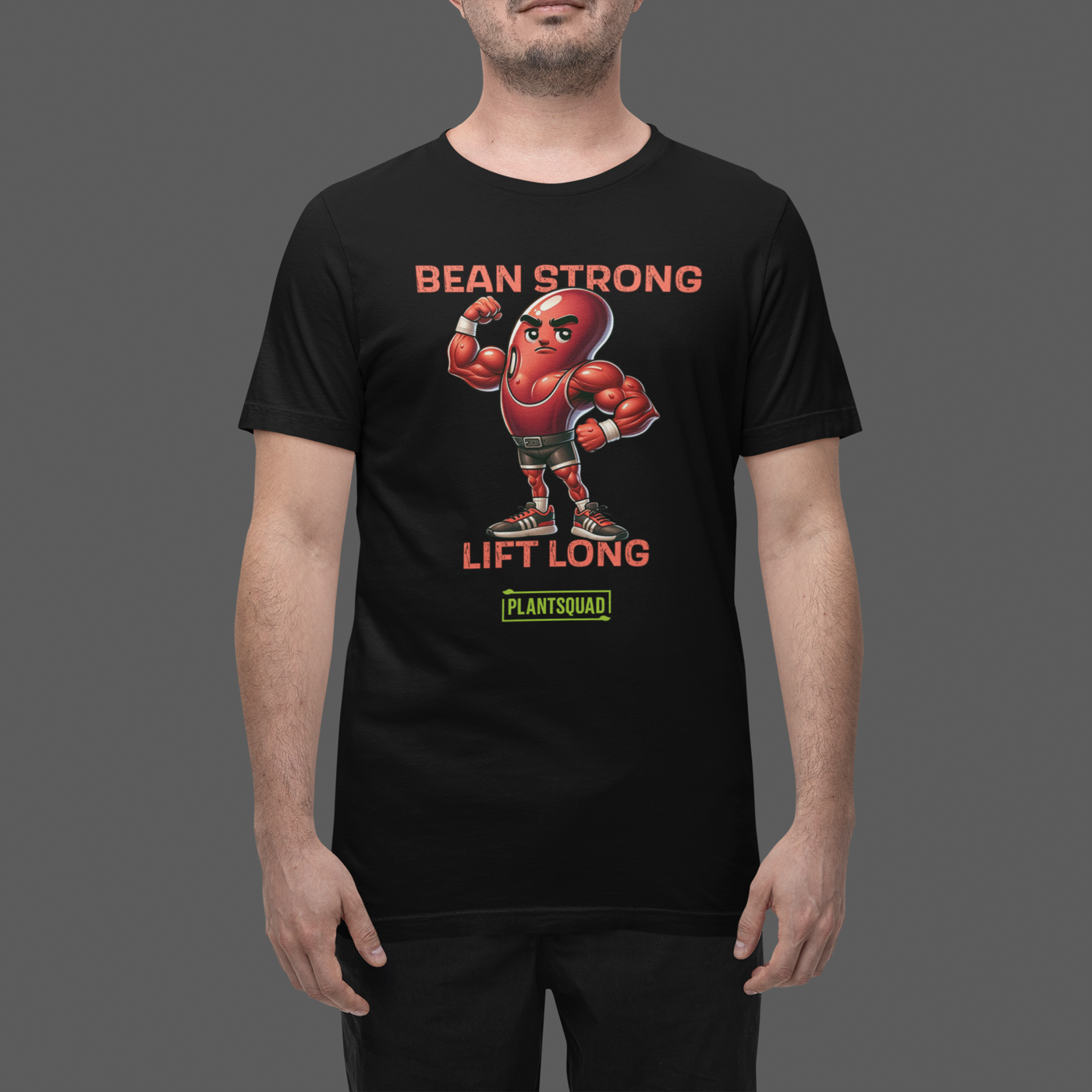 A black t-shirt featuring a muscular cartoon bean character flexing its arm. Above the character are the words "BEAN STRONG" and below it, "LIFT LONG." The bottom of this Plantsquad Kidney Bean "Bean Strong Lift Long" - Unisex T-Shirt proudly displays the "PLANTSQUAD" logo.