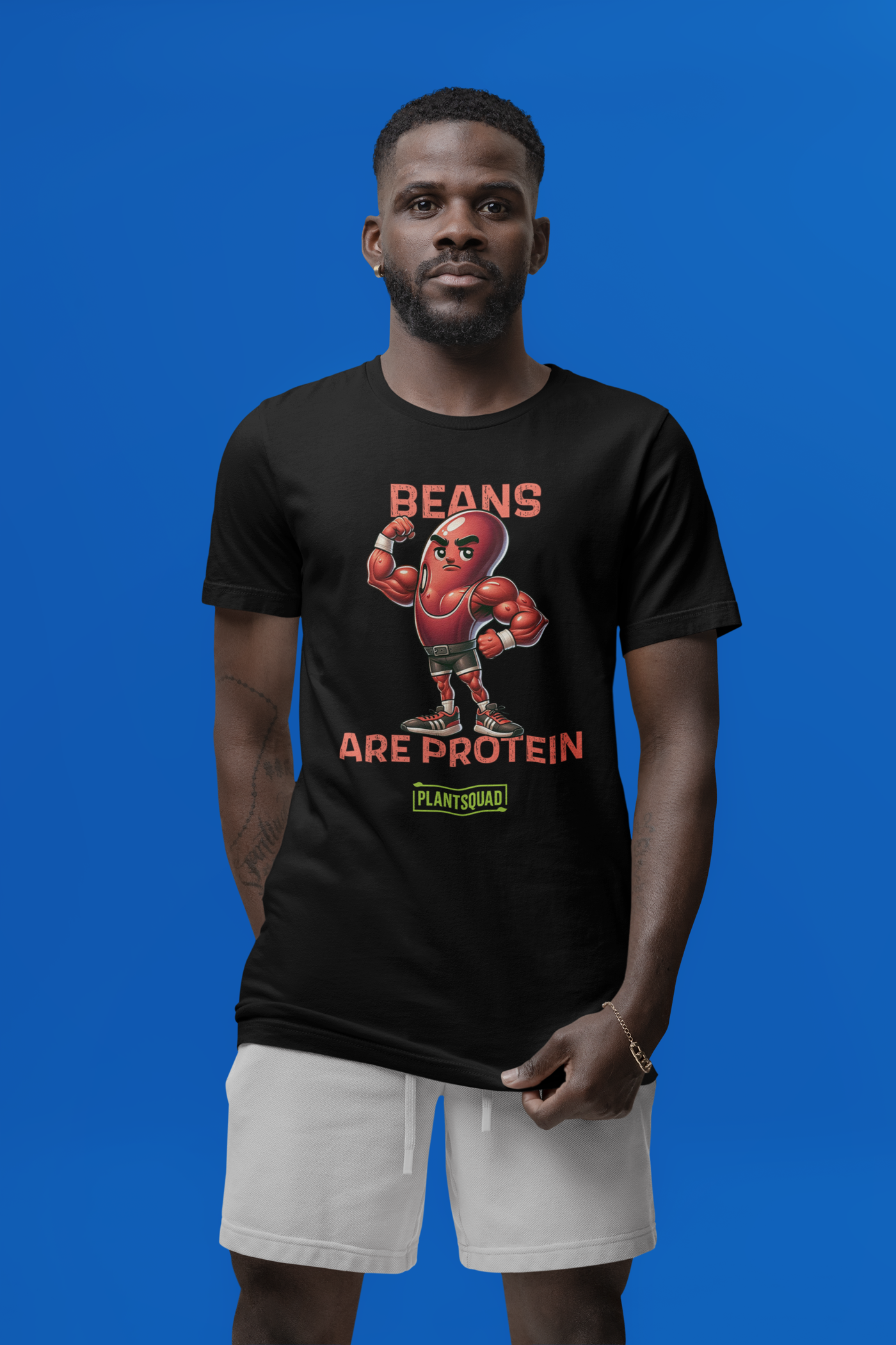 A black t-shirt featuring a muscular cartoon bean character with arms flexed. Above the character, red text reads "Beans," and below it, "Are Protein" is displayed in orange. Beneath that, the word "Plantsquad" is prominently written in green — Plantsquad Kidney Bean "Beans Are Protein" - Unisex T-Shirt.