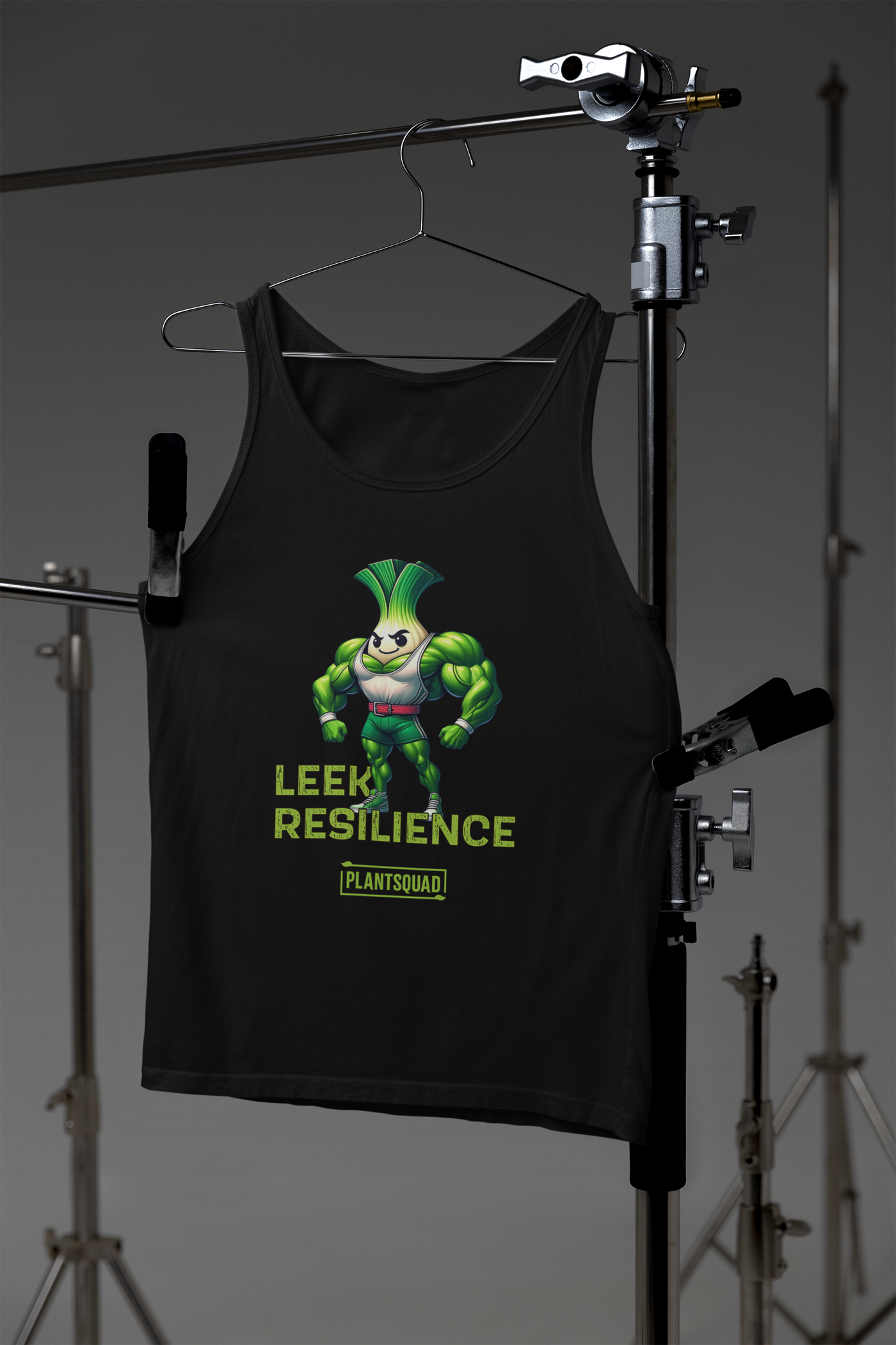 A Plantsquad Leek "Leek Resilience" - Unisex Tank Top featuring a muscular cartoon leek character. The text "LEEK RESILIENCE" is written in green below the character, and "PLANTSQUAD" is written at the bottom. Ideal for gym enthusiasts embracing a plant-based lifestyle, the leek has a determined expression and is flexing its arms.