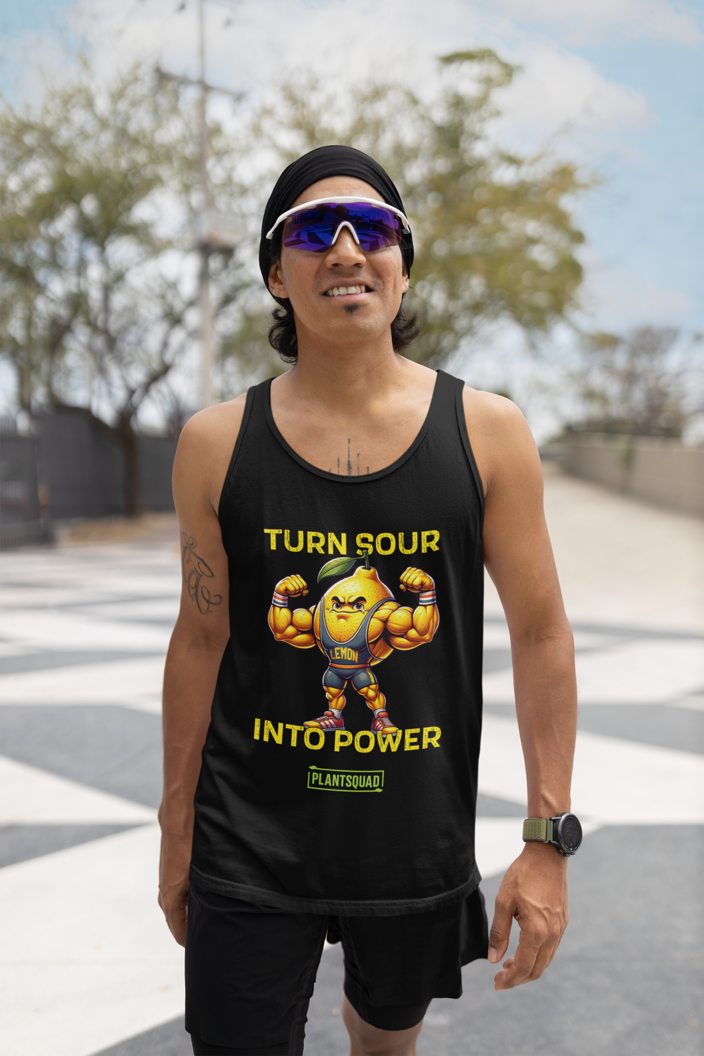 Black tank top with a muscular cartoon lemon flexing its arms. The lemon has a leaf on its head and is wearing a blue singlet labeled "LEMON." The text reads: "TURN SOUR INTO POWER," with a logo at the bottom reading "PLANTSQUAD." Perfect breathable workout tank for your plant-based lifestyle. Introducing the Plantsquad Lemon "Turn Sour Into Power" - Unisex Tank Top.