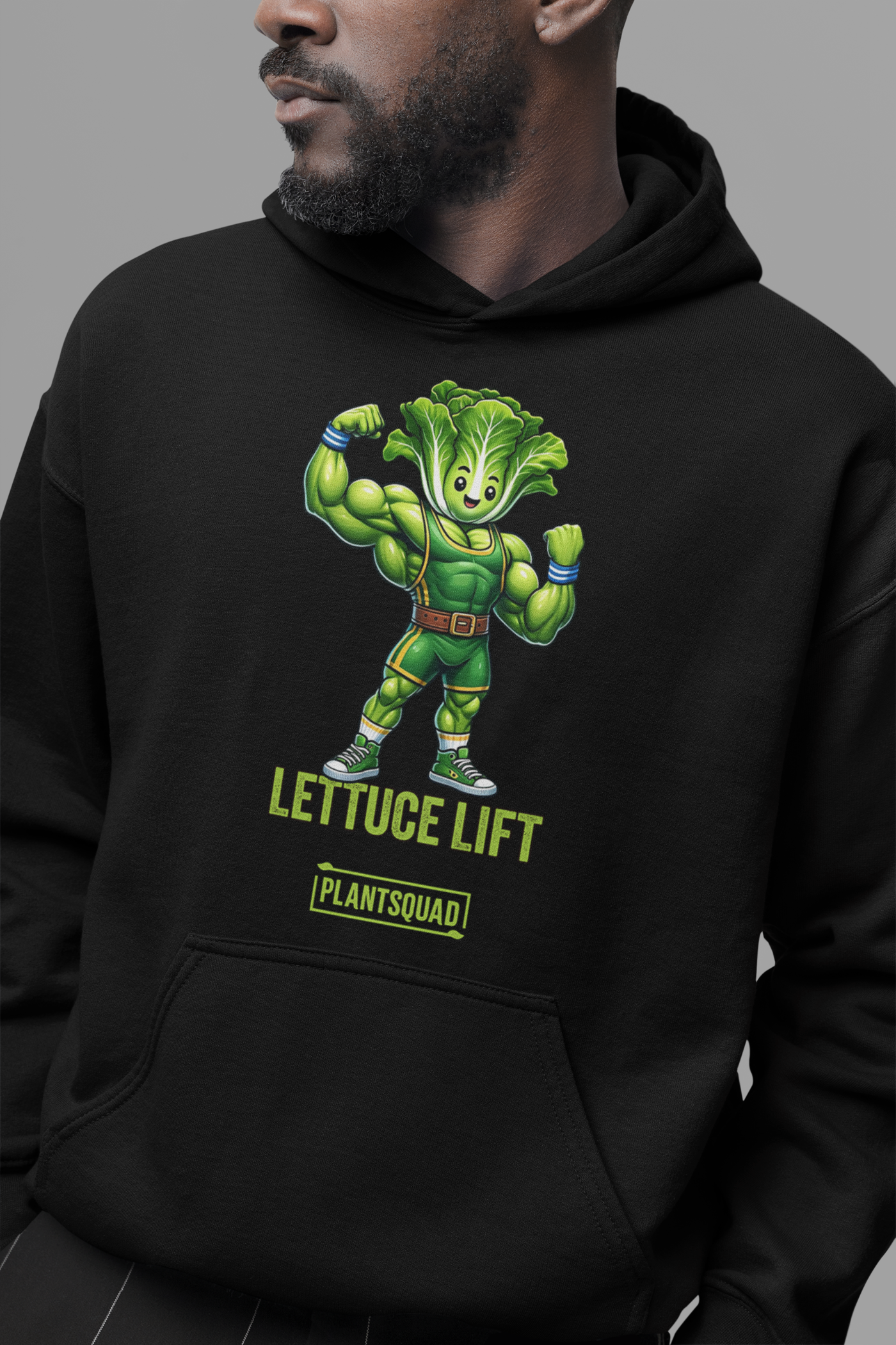 The Plantsquad Lettuce "Lettuce Lift" - Unisex Hoodie features a cartoon muscular head of lettuce with a determined expression, flexing its arms. Below it, the text reads "LETTUCE LIFT" in bold yellow-green letters and "PLANTSQUAD" in a smaller green banner - perfect for embracing your vegan lifestyle and weight lifting passion.