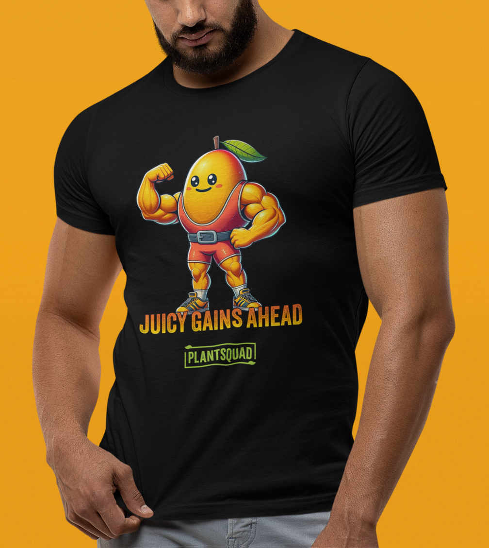 A black Plantsquad Mango "Juicy Gains Ahead" - Unisex T-Shirt featuring a muscular, anthropomorphic orange fruit character with a leaf on its head, flexing its biceps. Text below the character reads "JUICY GAINS AHEAD" with "PLANTSQUAD" in a box underneath. Perfect fitness apparel for those living a plant-based lifestyle.