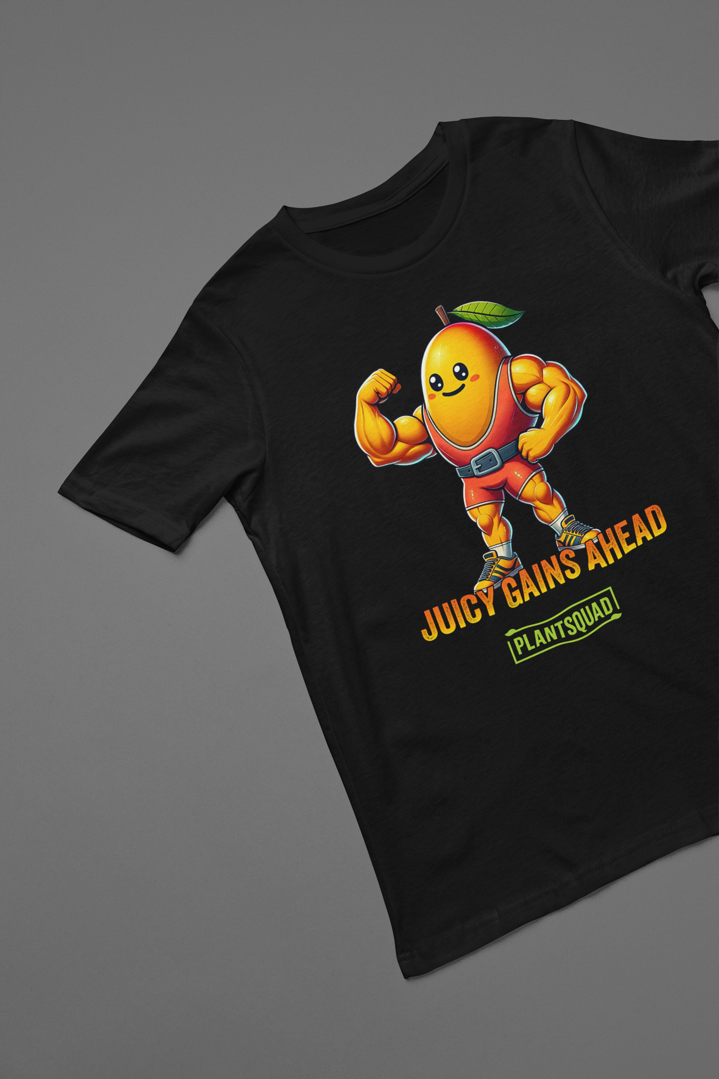 A black Plantsquad Mango "Juicy Gains Ahead" - Unisex T-Shirt featuring a muscular, anthropomorphic orange fruit character with a leaf on its head, flexing its biceps. Text below the character reads "JUICY GAINS AHEAD" with "PLANTSQUAD" in a box underneath. Perfect fitness apparel for those living a plant-based lifestyle.