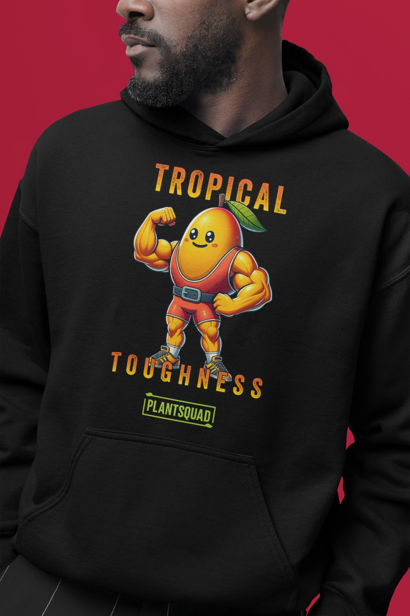 A Plantsquad Mango "Tropical Toughness" - Unisex Hoodie features a muscular, anthropomorphic mango character wearing superhero gear. The character is flexing its muscles, showcasing the benefits of a vegan lifestyle. Above it, text reads "Tropical Toughness," and below, a green label says "PLANTSQUAD.