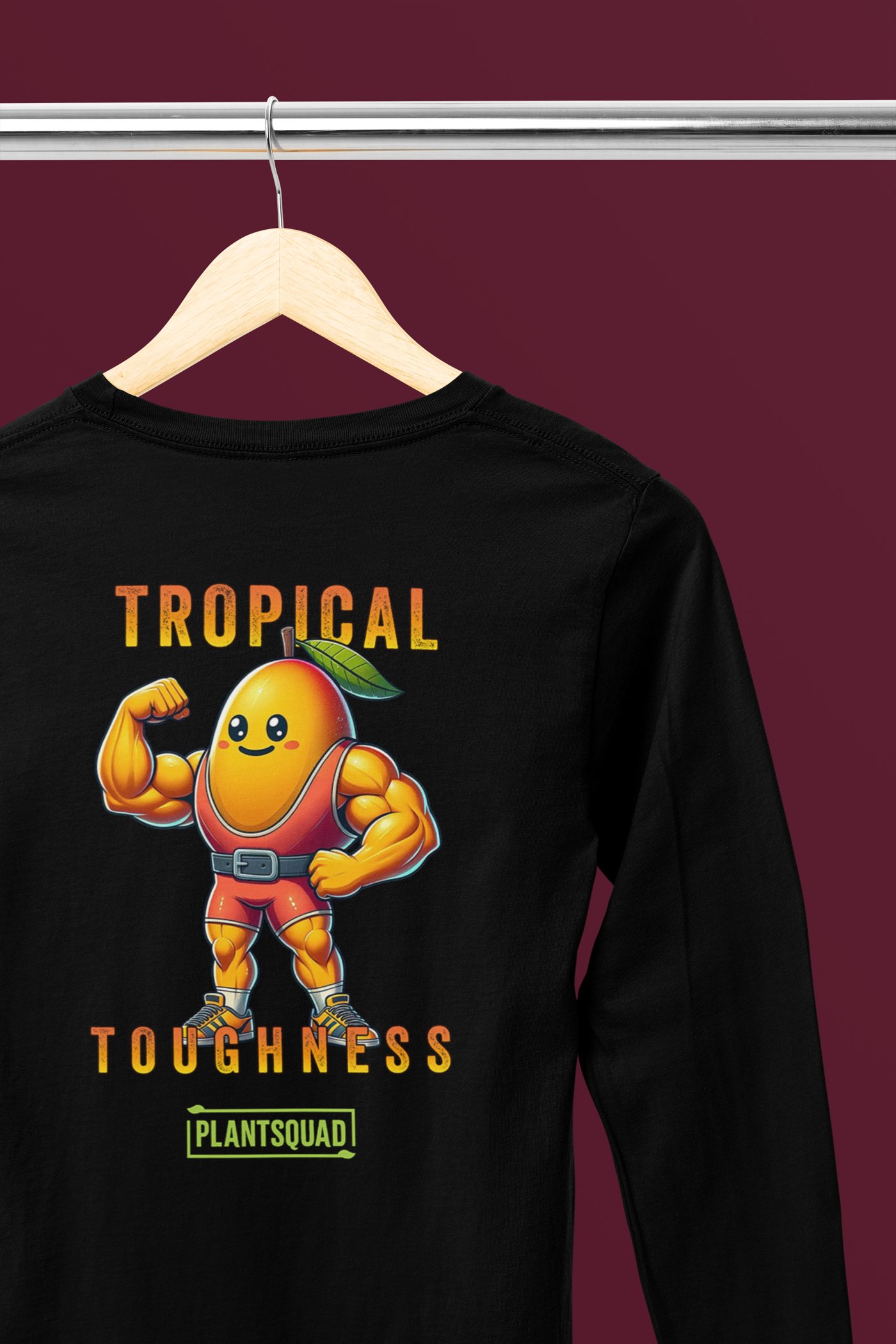 The Plantsquad Mango "Tropical Toughness" - Unisex Long Sleeve T-Shirt features a muscular, animated mango character dressed in red workout gear. The text "Tropical Toughness" is printed above and below the mango, with "Plantsquad" at the bottom. Perfect for fitness enthusiasts embracing a vegan lifestyle.