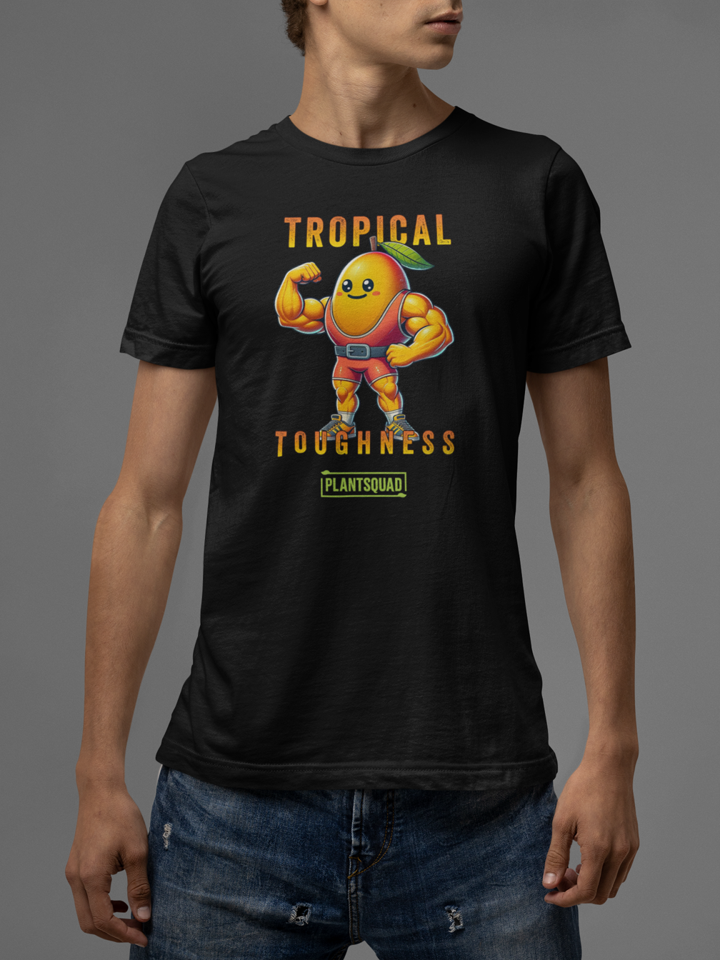 The Plantsquad Mango "Tropical Toughness" - Unisex T-Shirt features a muscly mango cartoon flexing its biceps. The text above the mango reads "Tropical" and below it reads "Toughness," capturing the essence of a vegan lifestyle. Below this, "PLANTSQUAD" is written inside a green rectangle on breathable fabric.