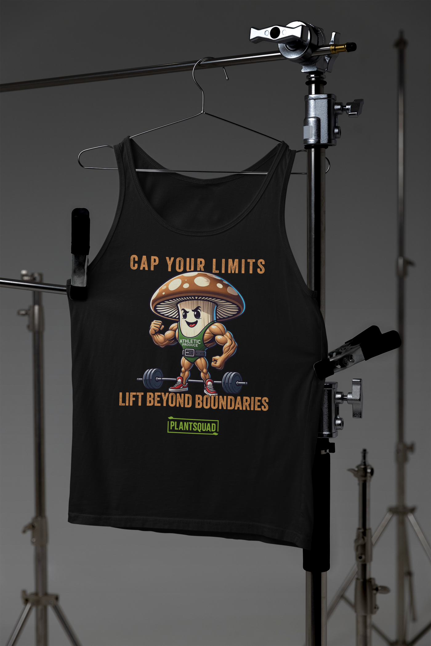 A Plantsquad Mushroom "Cap Your Limits Lift Beyond Boundaries" - Unisex Tank Top featuring a muscly mushroom design, lifting a barbell. The text reads, "CAP YOUR LIMITS LIFT BEYOND BOUNDARIES" at the top and "PLANTSQUAD" at the bottom. The vegan lifestyle-inspired mushroom wears a green shirt labeled "ATHLETIC.