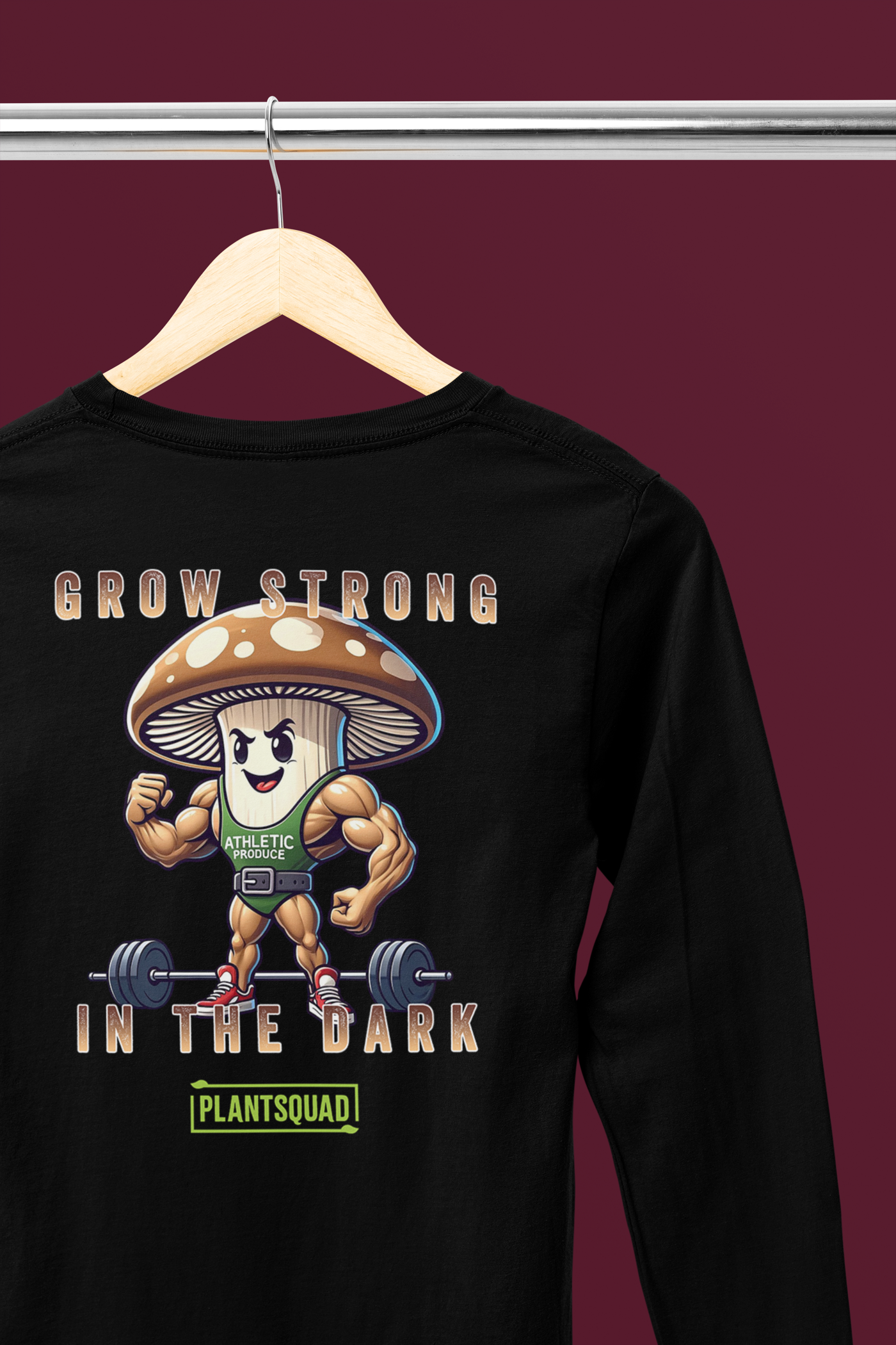 A Plantsquad Mushroom "Grow Strong In The Dark" - Unisex Long Sleeve T-Shirt with a muscly mushroom cartoon character lifting dumbbells. The text above reads, "GROW STRONG IN THE DARK," and below the character, it says, "PLANTSQUAD." Perfect for fitness enthusiasts who embrace a vegan lifestyle, the mushroom has a determined expression and flexes its muscles.