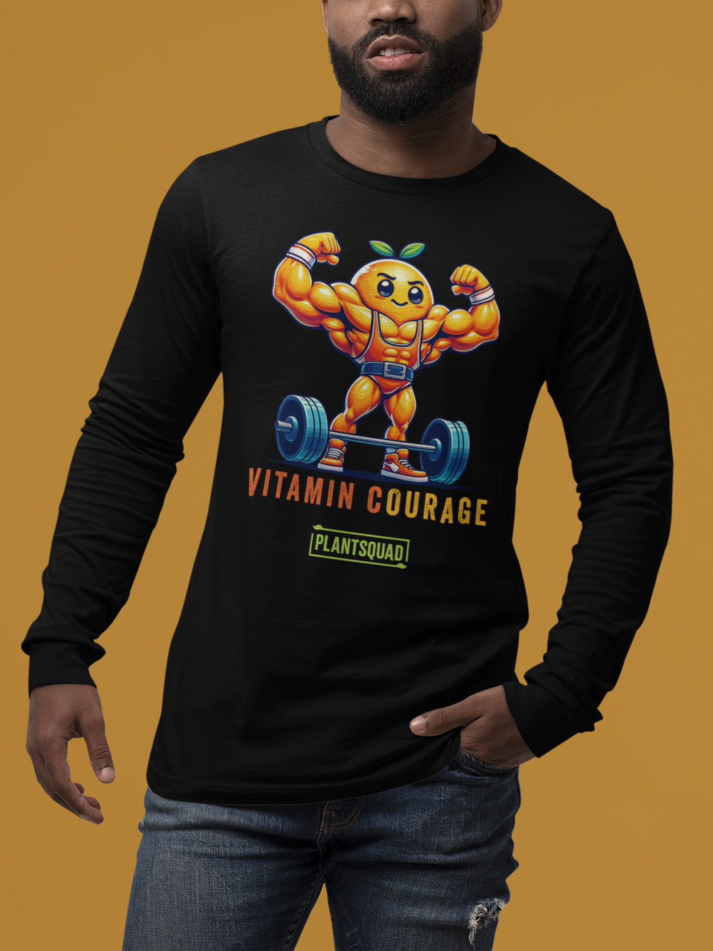 A black long-sleeve shirt features a muscular orange cartoon character lifting weights and flexing its arms. Text below the character reads "VITAMIN COURAGE" in orange letters and "PLANTSQUAD" in a green box, making it perfect for fitness enthusiasts embracing a vegan lifestyle. This is the Plantsquad Orange "Vitamin Courage" - Unisex Long Sleeve T-Shirt.