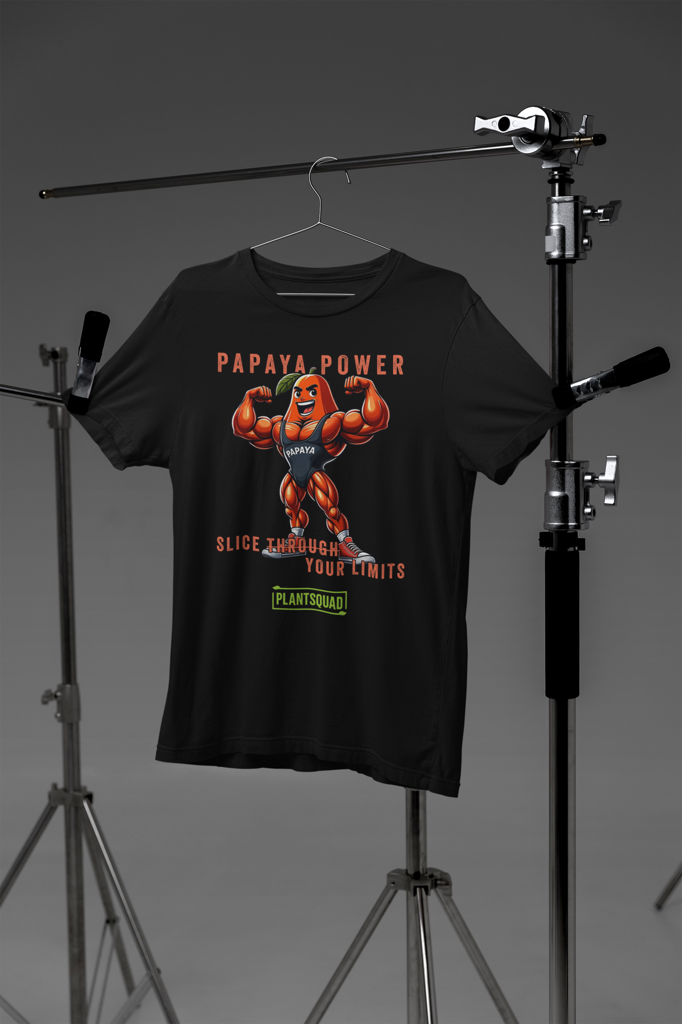 A black Plantsquad Papaya "Papaya Power Slice Through Your Limits" - Unisex T-Shirt featuring a muscular cartoon papaya flexing its arms with the text "PAPAYA POWER" above. Below, the phrase "SLICE THROUGH YOUR LIMITS" is written, celebrating a vegan lifestyle for fitness enthusiasts, with the brand name "PLANTSQUAD" at the bottom.