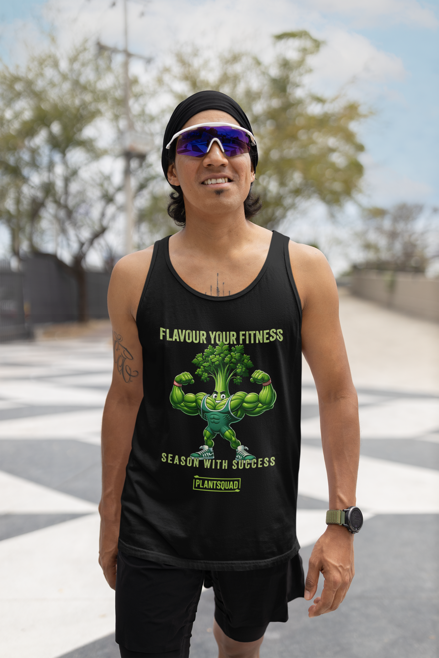 A black Plantsquad Parsley "Flavour Your Fitness Season With Success" - Unisex Tank Top featuring a cartoon image of a muscular broccoli flexing its arms. Above the broccoli, the text reads "FLAVOUR YOUR FITNESS" and below, it states "SEASON WITH SUCCESS." At the bottom, the text "PLANTSQUAD" is displayed. Perfect for your plant-based lifestyle or vegan gym wear collection.