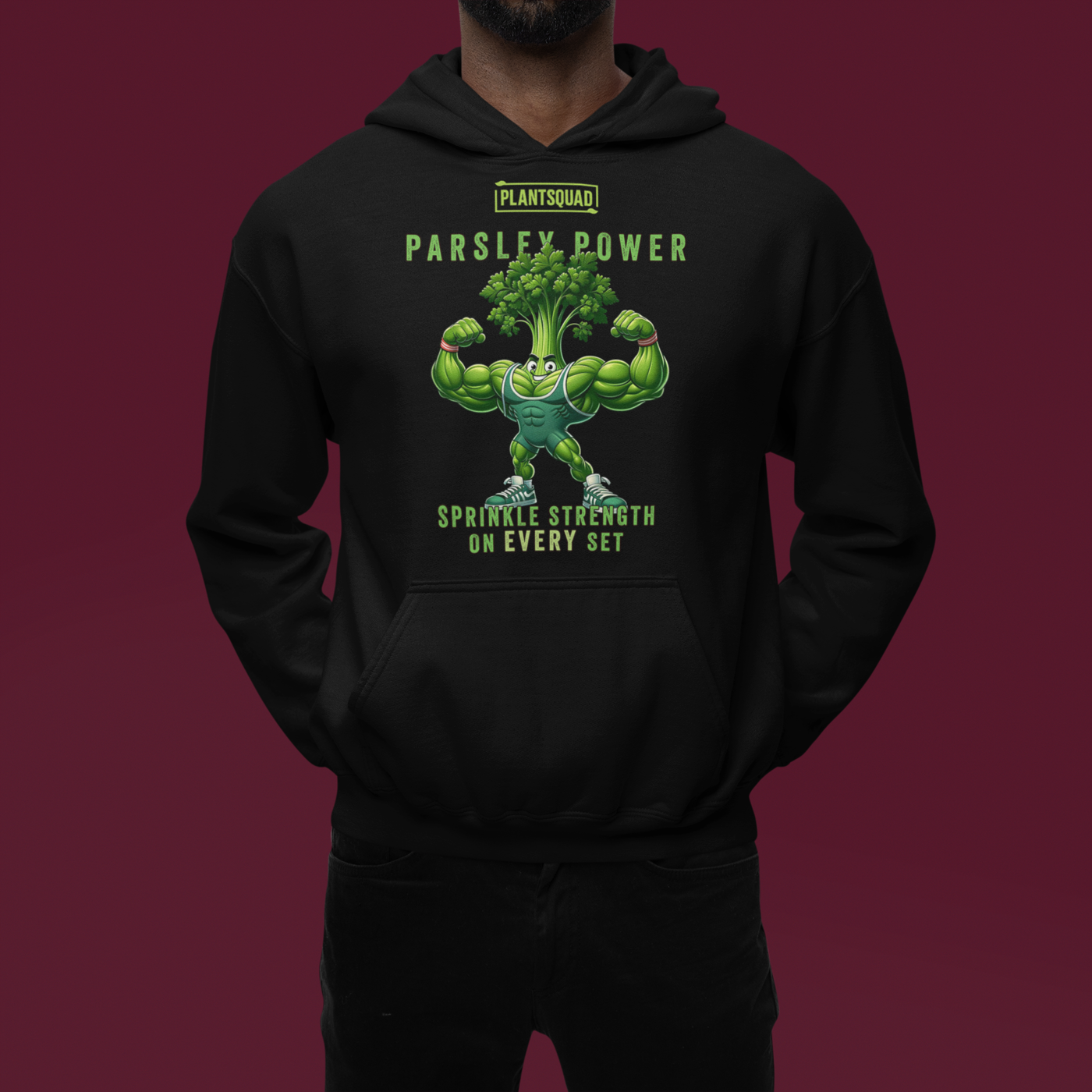 A black Plantsquad Parsley "Parsley Power Sprinkle Strength On Every Set" - Unisex Hoodie featuring a muscular cartoon parsley character flexing its arms. Above the character is the text "PLANTSQUAD" and "PARSLEY POWER." Below, it reads "SPRINKLE STRENGTH ON EVERY SET." The design is in shades of green and white, perfect for vegan gym apparel enthusiasts.