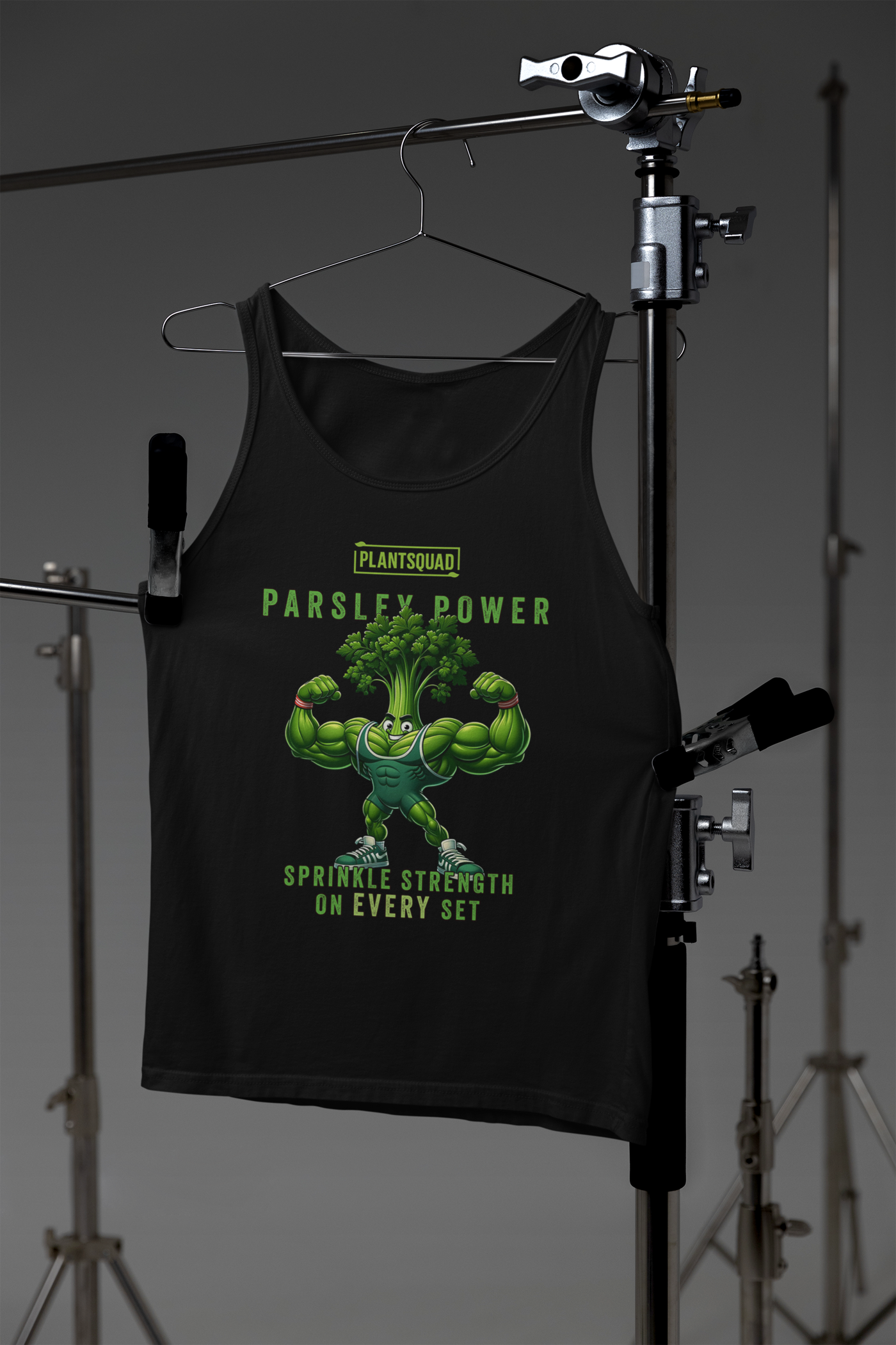 A black tank top features an illustration of a muscular anthropomorphic parsley plant flexing its biceps. Above the character, text reads "PLANTSQUAD PARSLEY POWER," and below it, the text says "SPRINKLE STRENGTH ON EVERY SET." Perfect for gym enthusiasts embracing a plant-based lifestyle, the Plantsquad Parsley "Parsley Power Sprinkle Strength On Every Set" - Unisex Tank Top is a must-have.