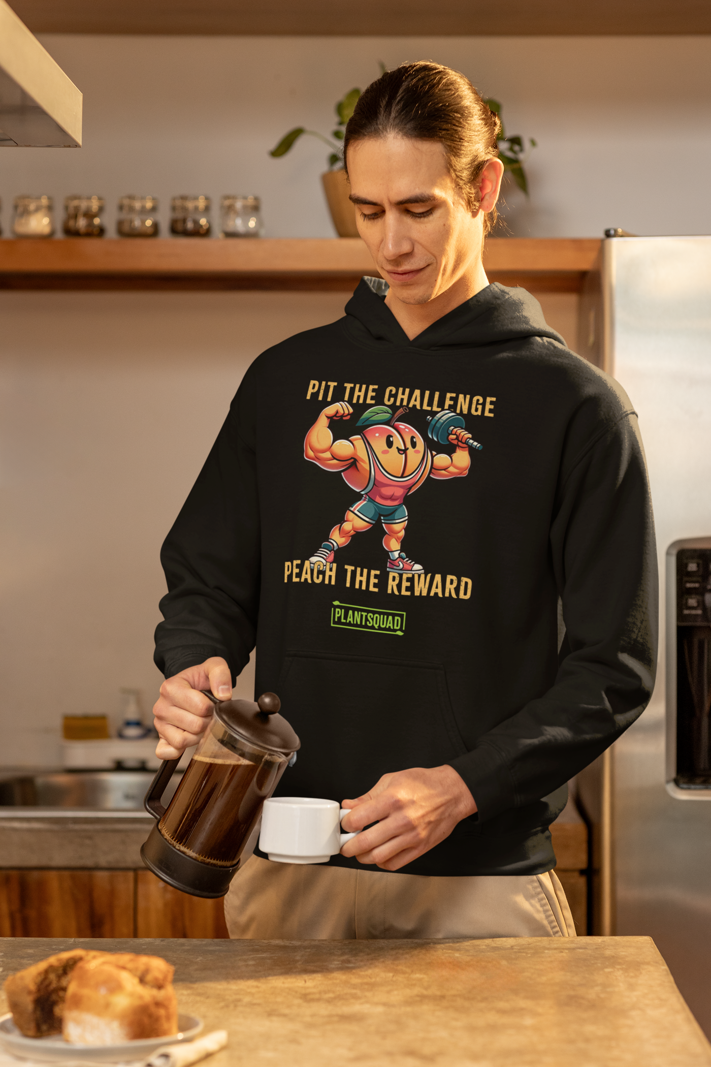 A Plantsquad Peach "Pit The Challenge Peach The Rewards" - Unisex Hoodie featuring a cartoon muscular peach lifting weights with green leaves as arms. Crafted from cozy fabric, the text above the peach reads "Pit the Challenge" and below it "Peach the Reward." Perfect for promoting a vegan lifestyle, the brand name "Plant Squad" appears at the bottom.