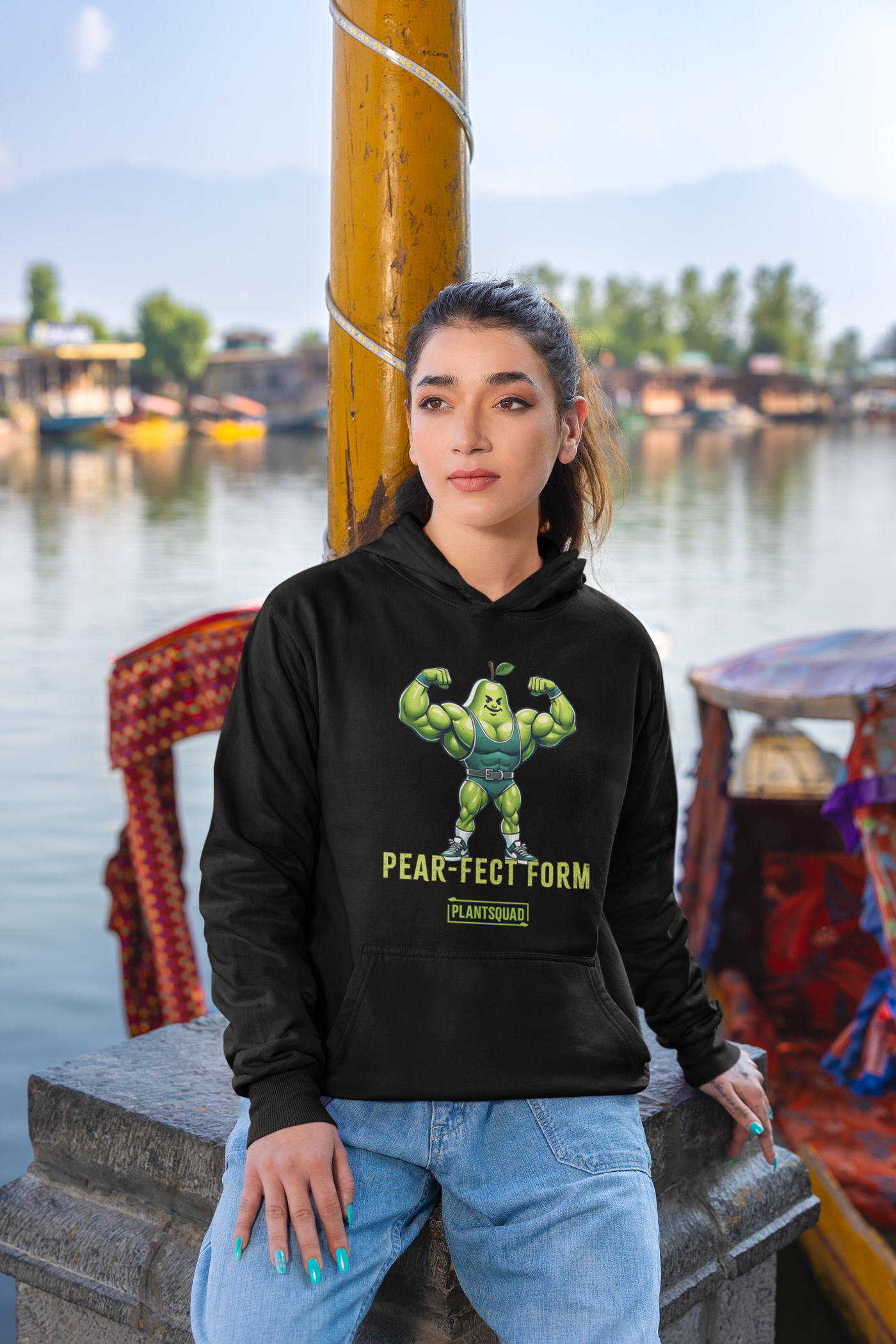 Plantsquad Pear "Pear-fect Form" - Unisex Hoodie featuring a cozy fabric and an illustration of a muscular pear cartoon flexing its biceps while wearing a blue weightlifting belt. The text underneath the pear reads "Pear-Fect Form" and below that is the logo "PlantSquad," perfect for showcasing your vegan lifestyle.