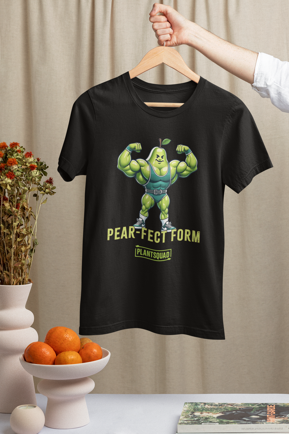 A Plantsquad Pear "Pear-fect Form" - Unisex T-Shirt featuring an illustration of a muscular, flexing pear with a green leaf on top, wearing gym clothes and sneakers. Crafted from breathable fabric, it’s perfect for fitness enthusiasts. Below the image are the words "PEAR-FECT FORM" and "PLANT SQUAD" in yellow and green text.