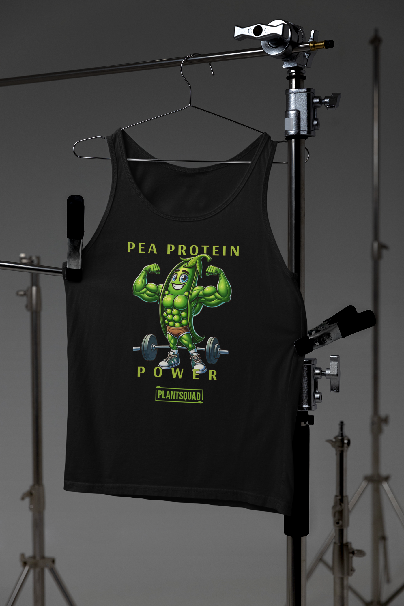 A black vegan workout tank, the Plantsquad Peas "Pea Protein Power" - Unisex Tank Top, features a muscular, anthropomorphic green pea flexing its biceps with a barbell on the ground behind it. Text above reads "Pea Protein Power" and below, "PlantSquad." The design promotes plant-based fitness.