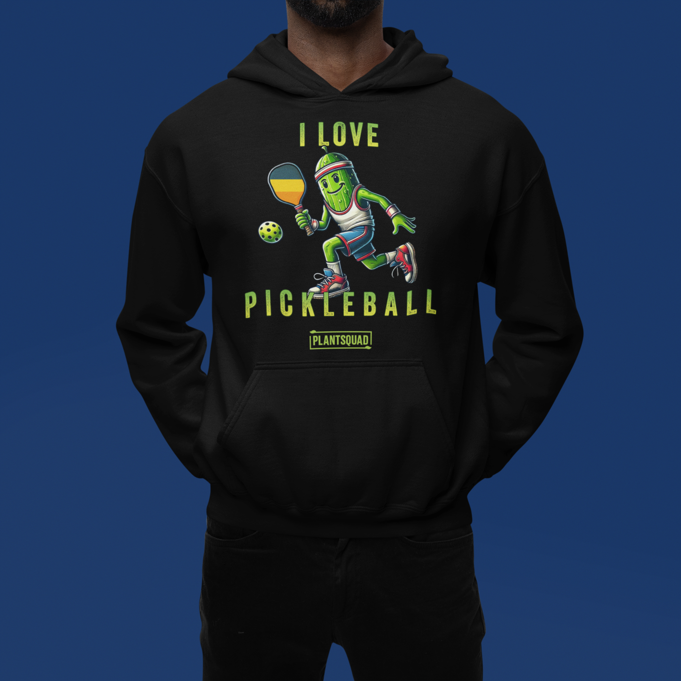 A hoodie featuring a pickle playing pickleball. There is a caption listed as "I Love Pickleball", with a small green logo "PLANTSQUAD" underneath. Perfect for those who love pickleball.