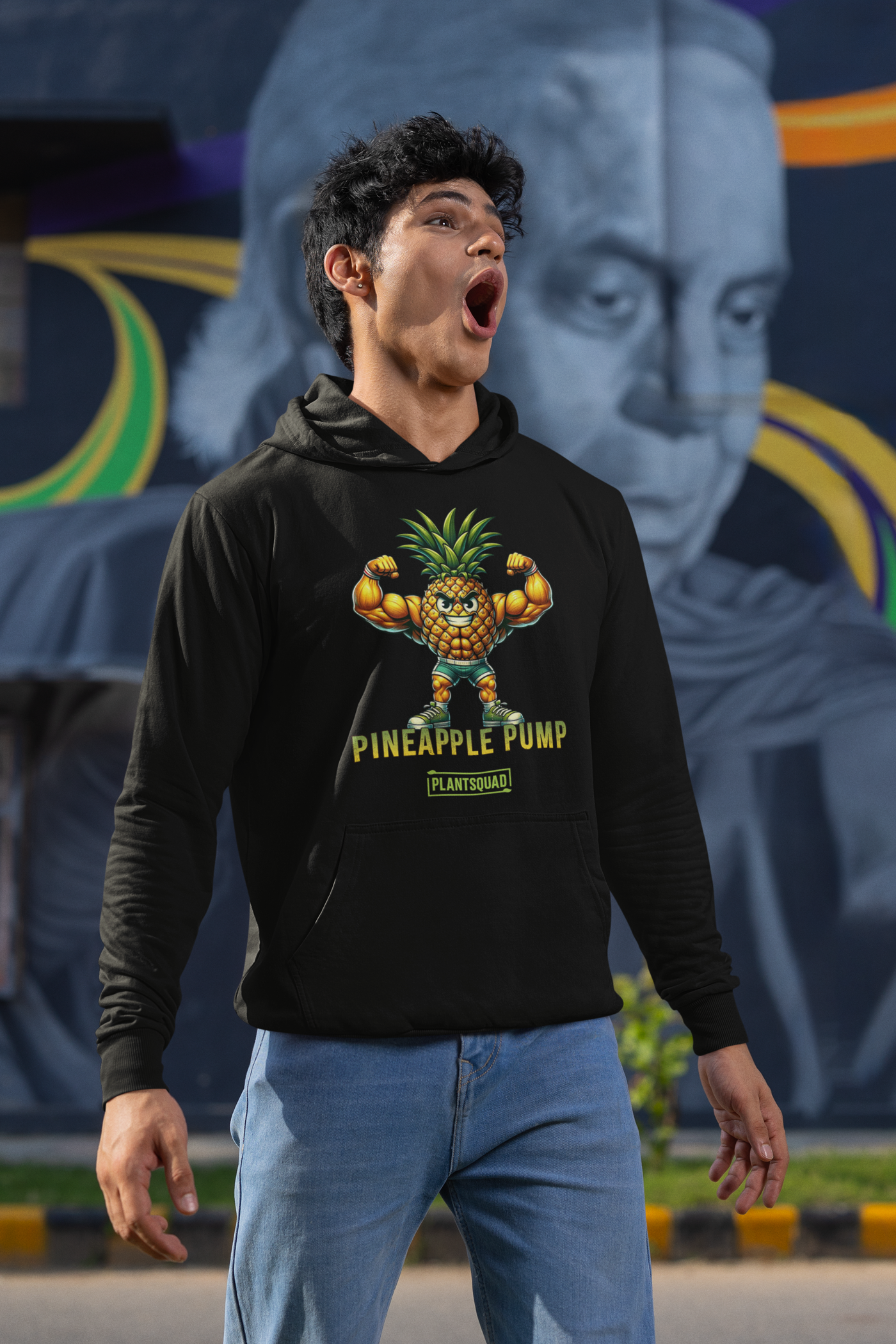 A black hooded sweatshirt features a muscular, anthropomorphic pineapple flexing its arms. Below the pineapple, the text reads "Pineapple Pump" with the brand name "PlantSquad" underneath. Perfect for gym enthusiasts embracing a vegan lifestyle, this Plantsquad Pineapple "Pineapple Pump" - Unisex Hoodie is both stylish and motivating.