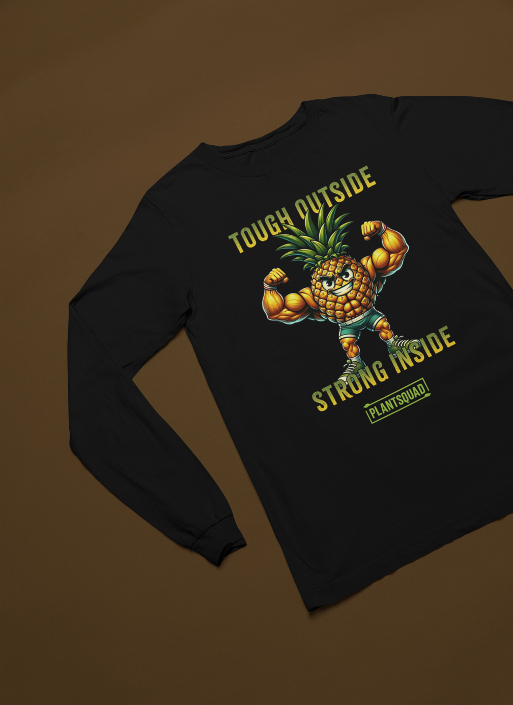 A black Plantsquad Pineapple "Tough Outside Strong Inside" - Unisex Long Sleeve T-Shirt features a muscly pineapple cartoon flexing with a fierce expression. The text "Tough Outside, Strong Inside" is printed above and below it, and "Plantsquad" is written at the bottom, celebrating a plant-based lifestyle and vegan fitness.