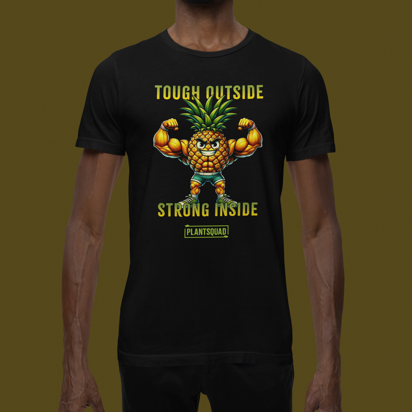 A black workout T-shirt features a muscular anthropomorphic pineapple flexing its biceps. Above the pineapple is the text "Tough Outside" and below it reads "Strong Inside." At the bottom, there's a green box with the word "Plantsquad Pineapple  'Tough Outside Strong Inside' - Unisex T-Shirt," perfect for anyone embracing a plant-based lifestyle.