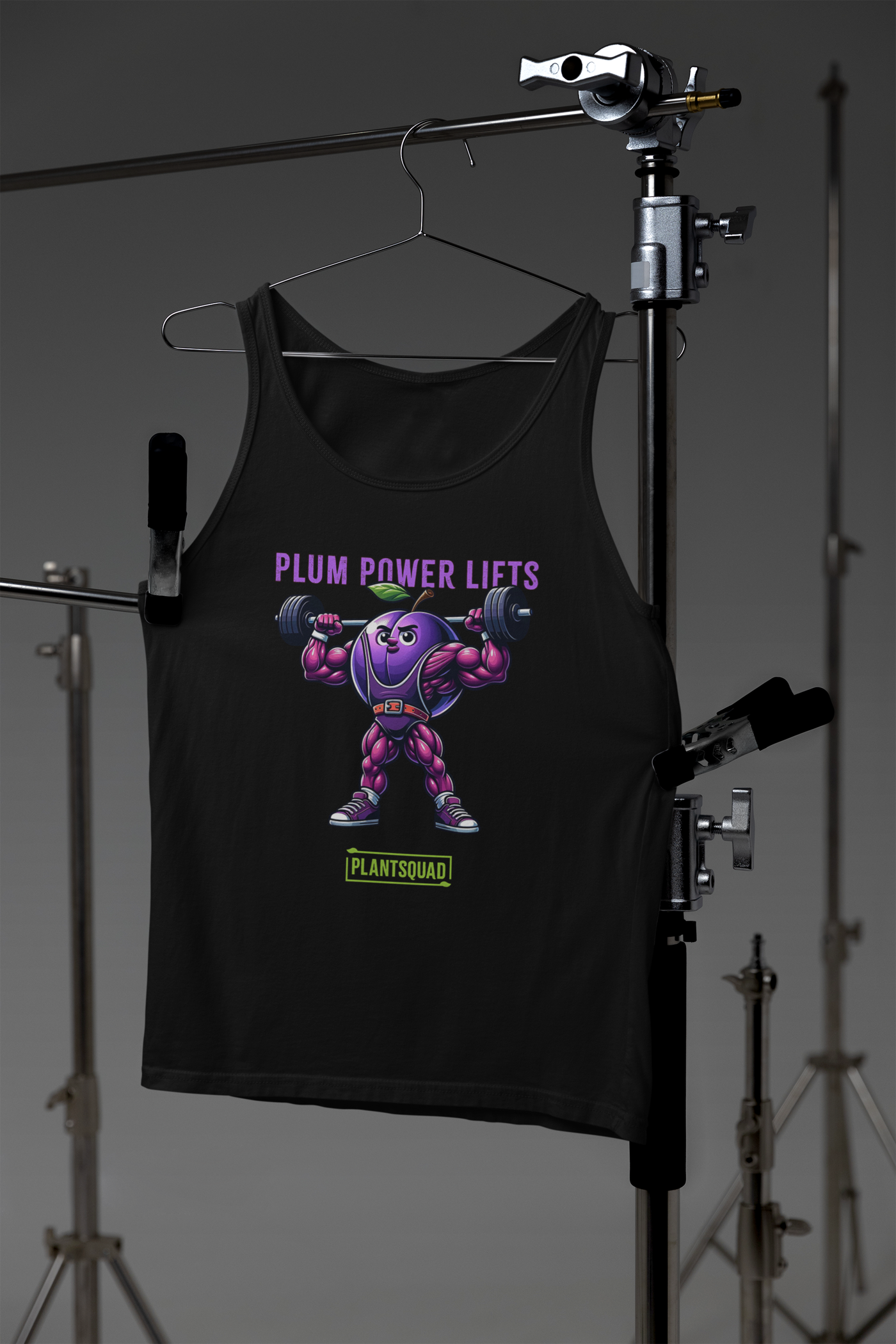 A black Plantsquad Plum "Plum Power Lifts" - Unisex Tank Top featuring a muscular cartoon plum lifting barbells. The text "PLUM POWER LIFTS" is displayed above the plum, and "PLANTSQUAD" is written at the bottom in green and white. Perfect for gym enthusiasts embracing a vegan lifestyle.