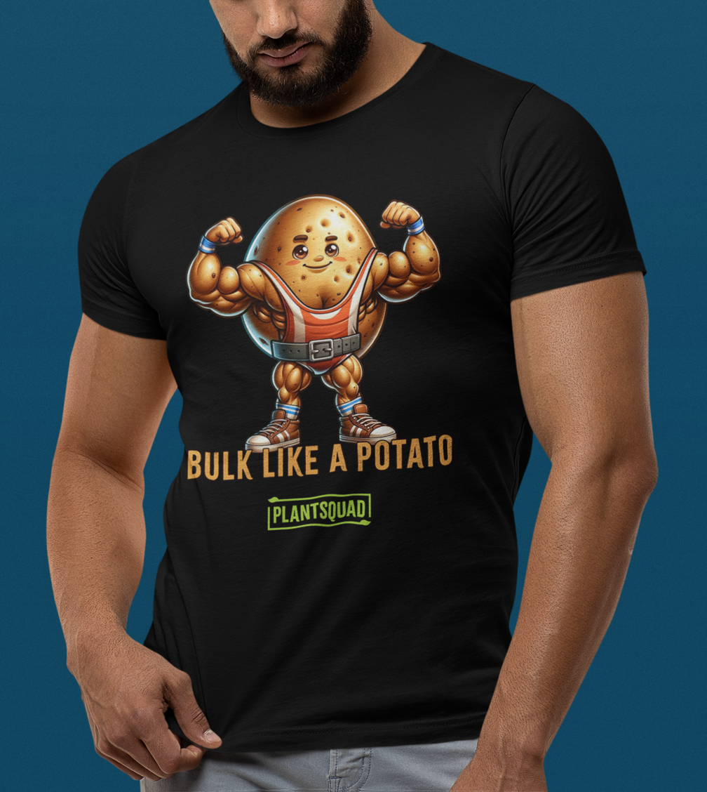 A black Plantsquad Potato "Bulk Like A Potato" - Unisex T-Shirt featuring a cartoon image of a muscular potato flexing its arms with a determined expression. Below the weight-lifting potato, the text reads "BULK LIKE A POTATO" in bold letters. The word "PLANTSQUAD" is also displayed towards the bottom in a green box, promoting a vegan lifestyle.