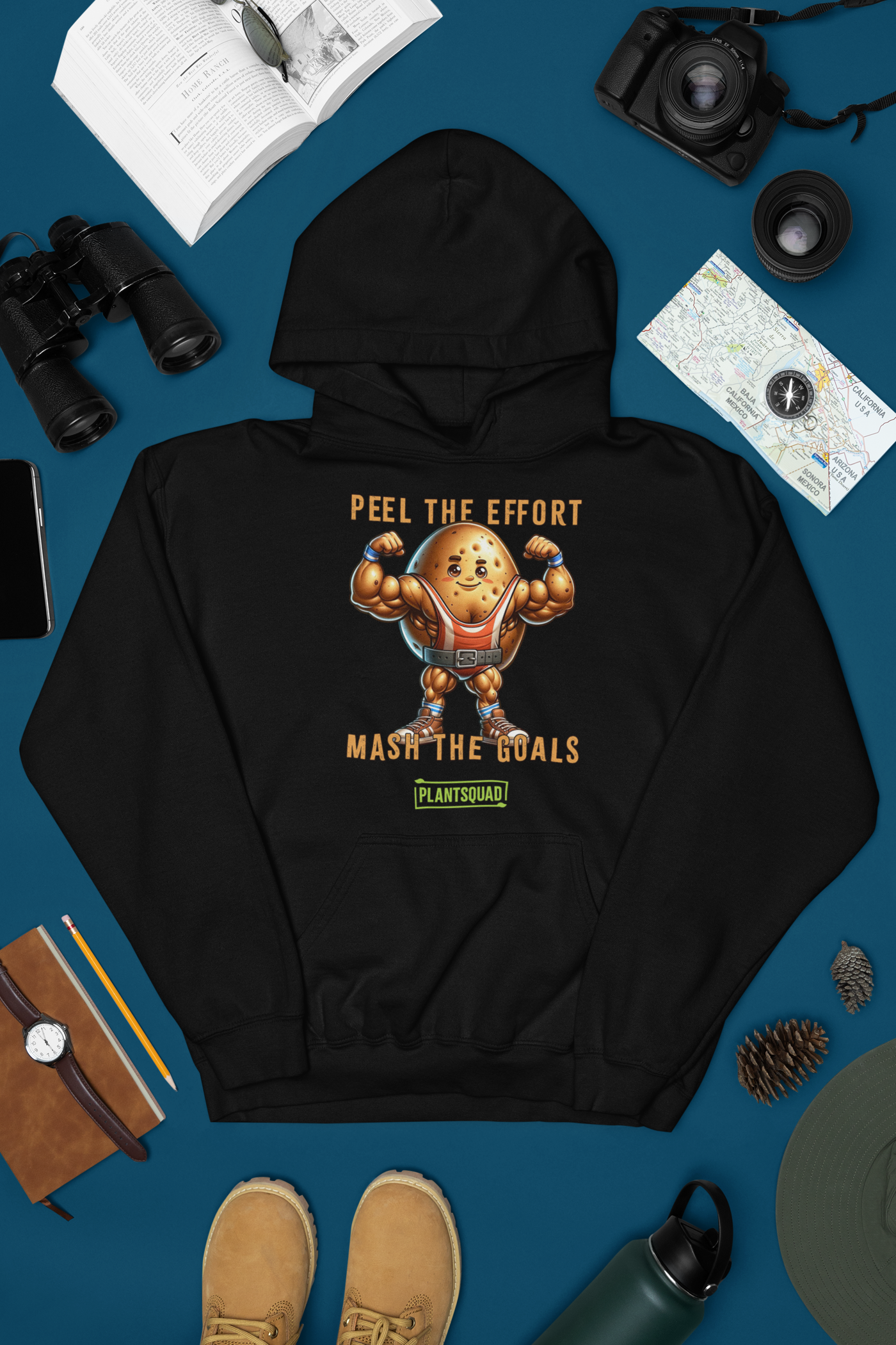 The Plantsquad Potato "Peel The Effort Mash The Goals" - Unisex Hoodie features a muscular potato character lifting weights. Above and below the potato, texts read "Peel The Effort" and "Mash The Goals." Promoting a vegan lifestyle, the word "PlantSquad" is displayed beneath the potato graphic.