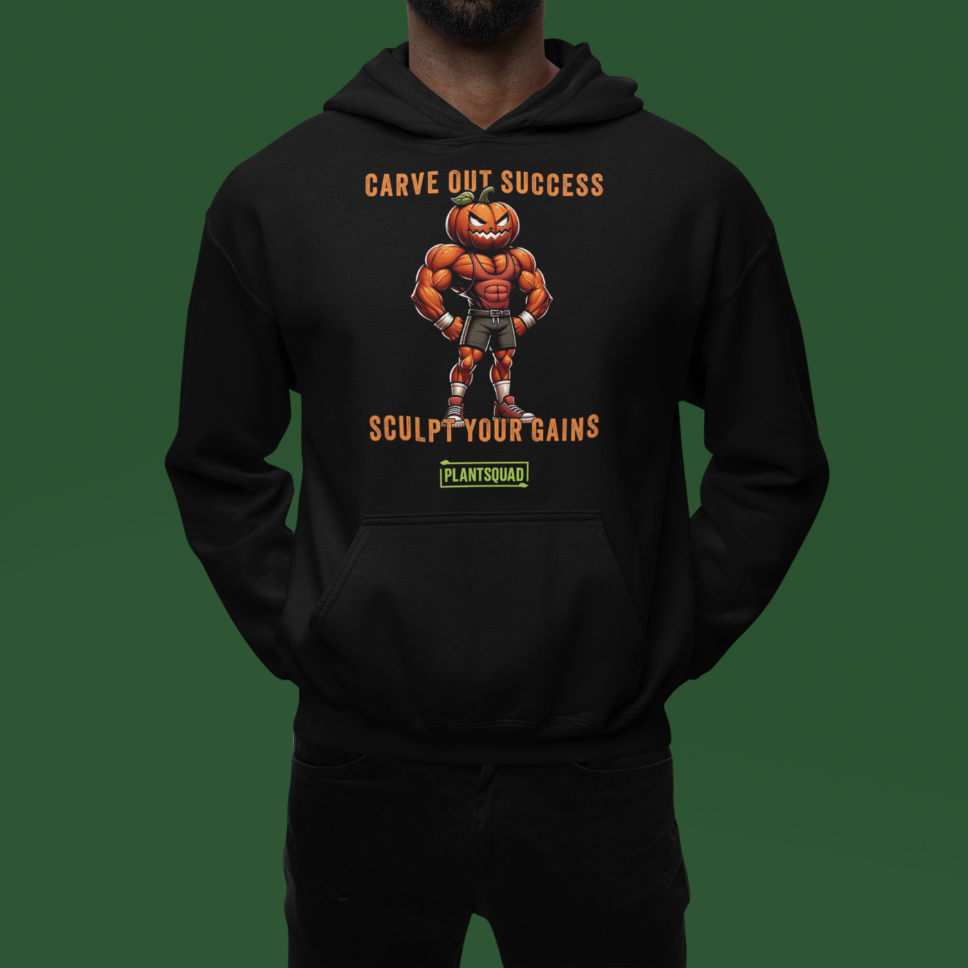 A black weight lifting hoodie features an illustration of a muscular pumpkin-headed figure in workout attire. The text above and below reads "Carve Out Success" and "Sculpt Your Gains," with a small "PlantSquad" logo at the bottom, celebrating the vegan lifestyle. This is the Plantsquad Pumpkin "Carve Out Your Success Sculpt Your Gains" - Unisex Hoodie.