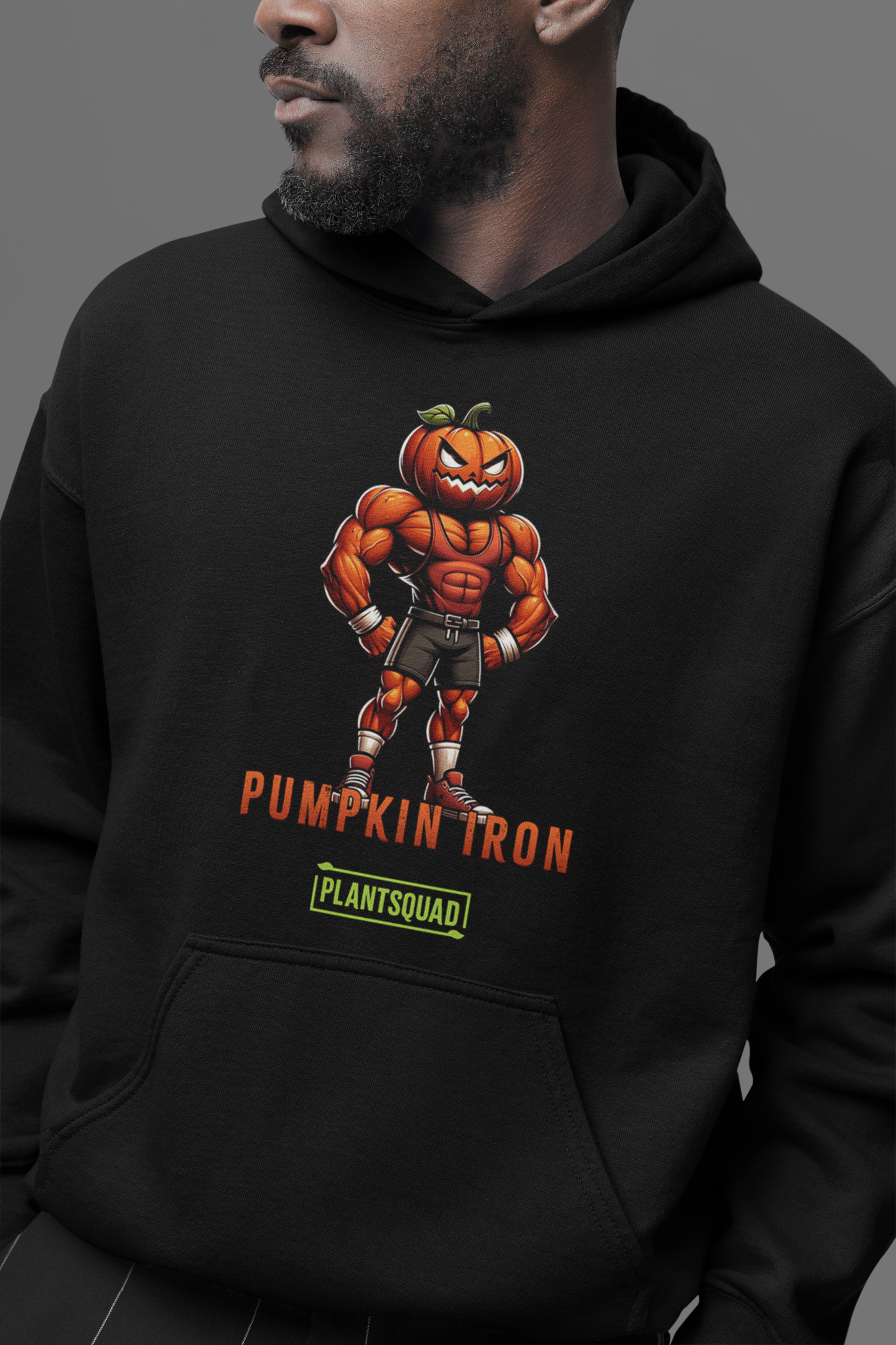 The Plantsquad Pumpkin "Pumpkin Iron" - Unisex Hoodie showcases a muscular pumpkin design, with a cartoon character flexing its muscles under the text "PUMPKIN IRON" in vibrant orange. Below, a green bar labeled "PLANTSQUAD" represents the vegan lifestyle, creating the perfect blend of fitness and plant-based living.